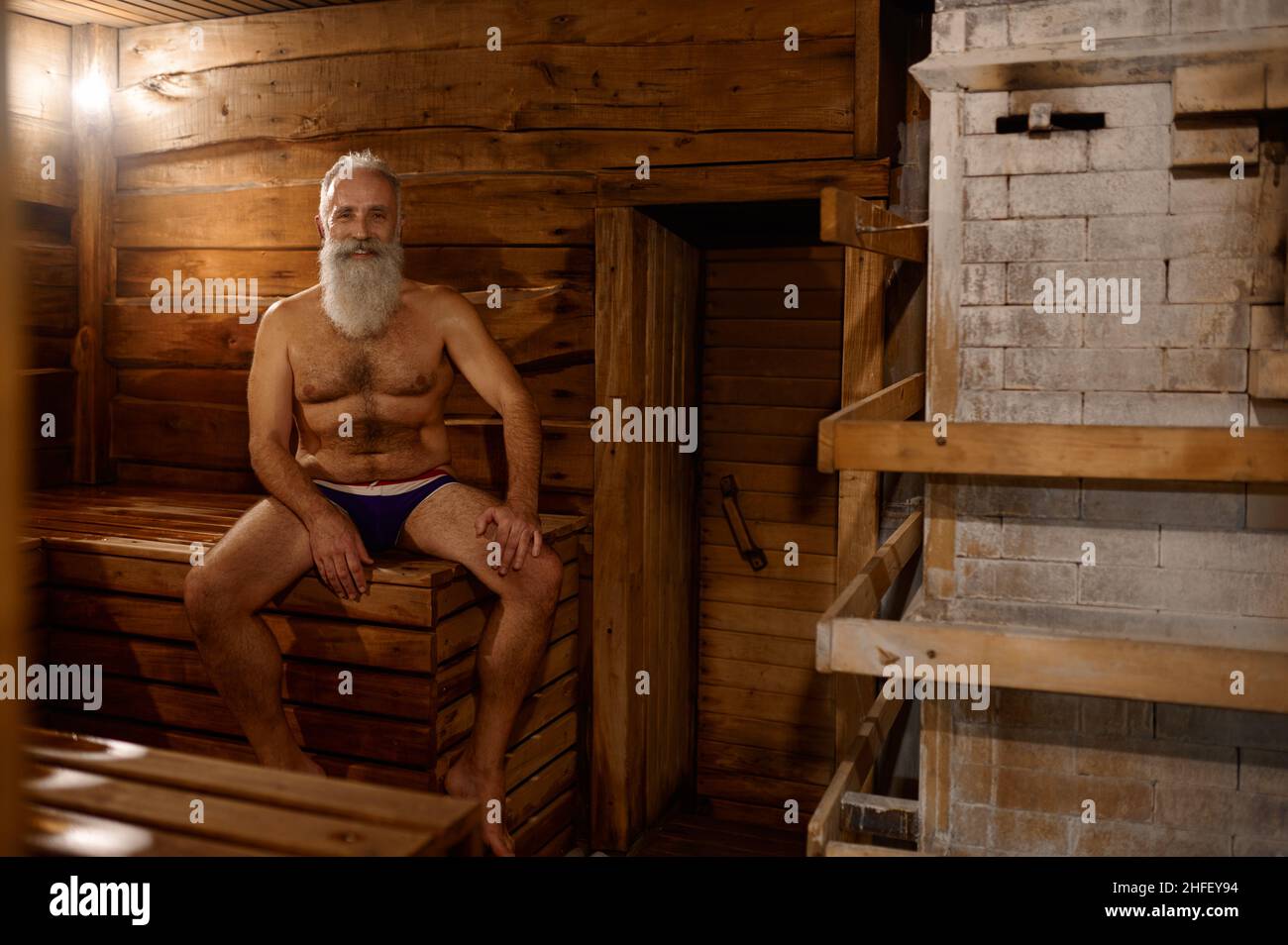 Il resto dell'uomo anziano grigio-haired alla casa del bagno Foto Stock