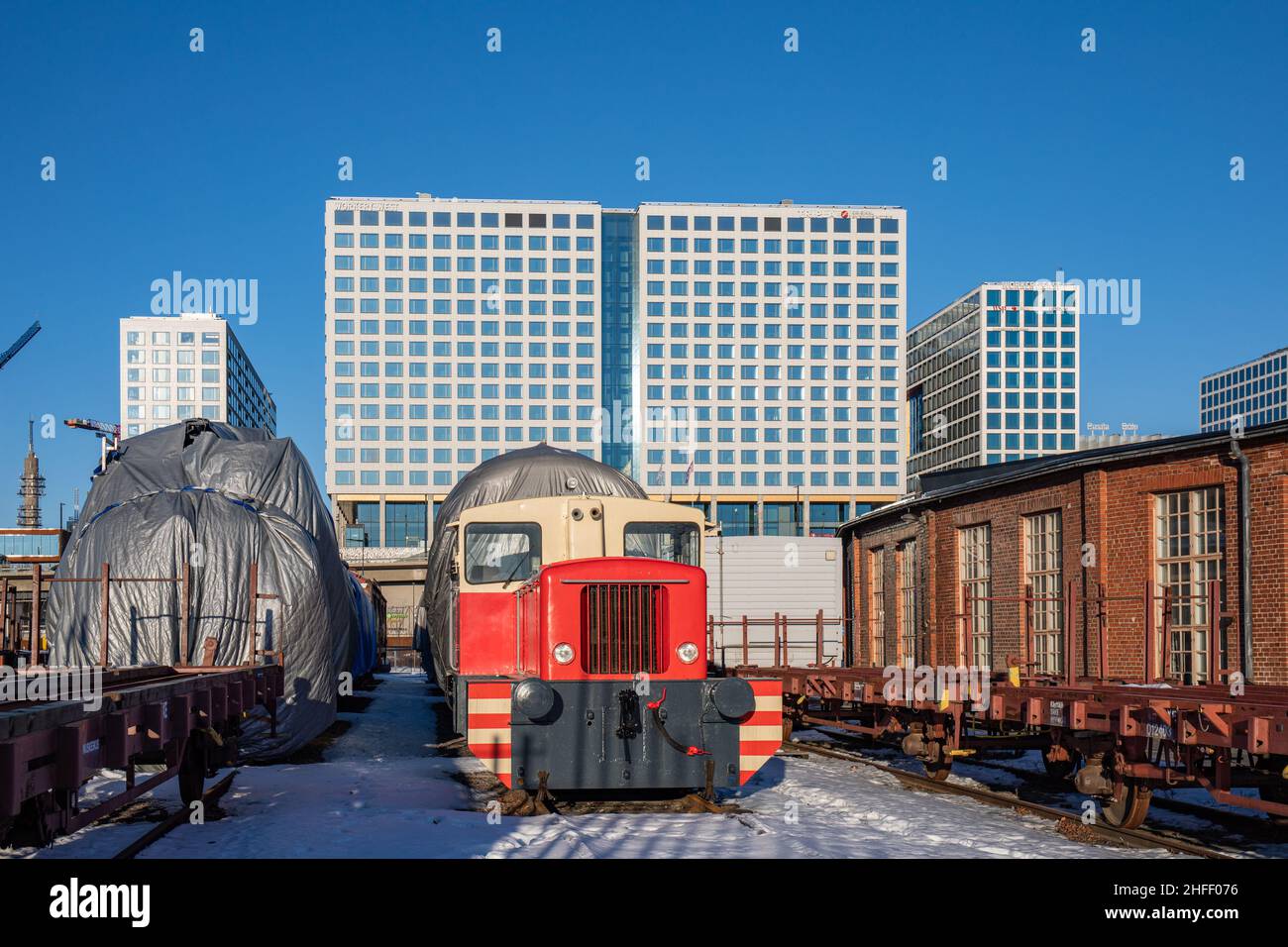 Locomotiva diesel nel vecchio cantiere ferroviario con edifici Mall of Tripla sullo sfondo nel distretto di Pasila di Helsinki, Finlandia Foto Stock