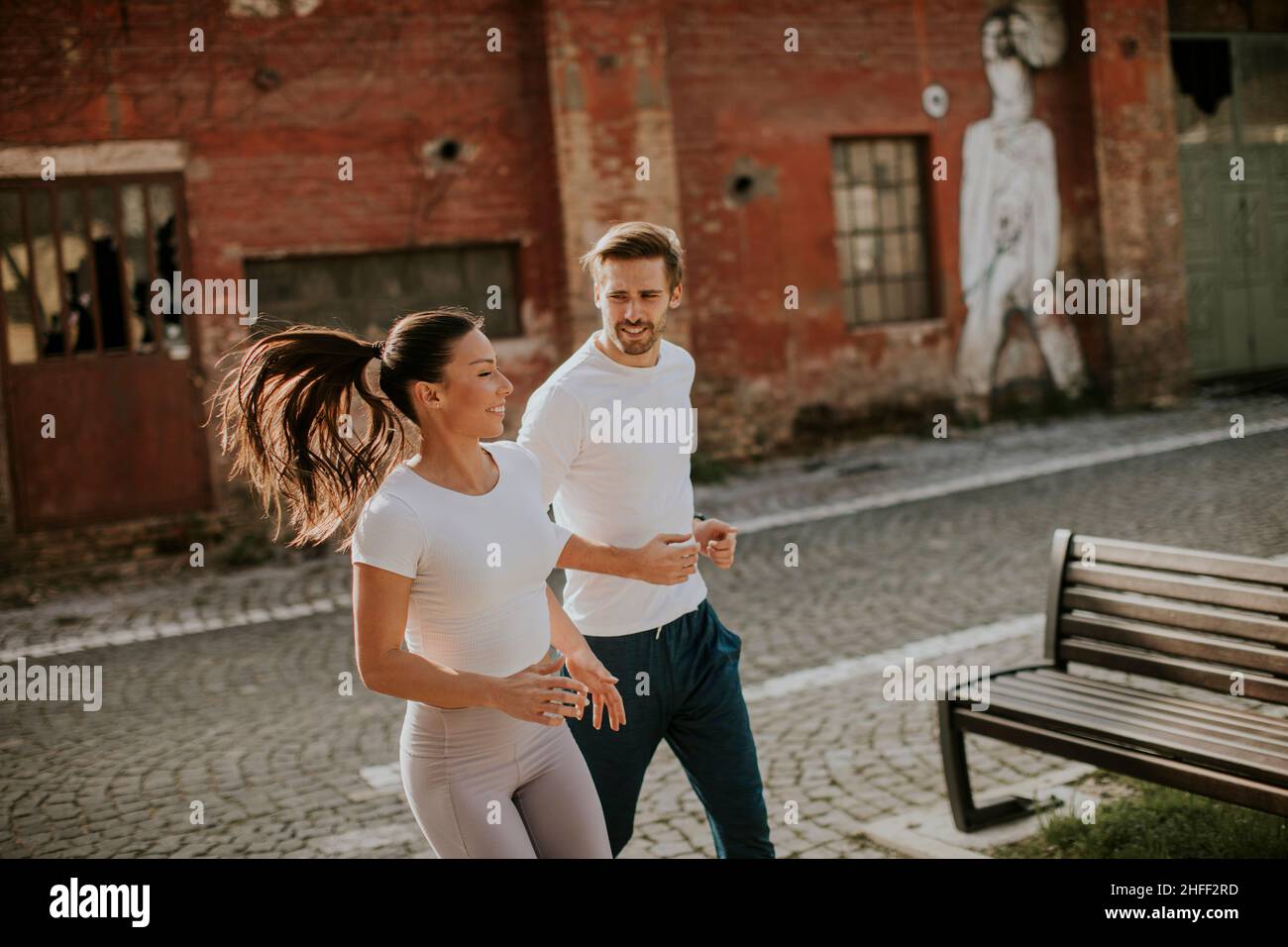Bella giovane coppia di fitness che corre in zona urbana Foto Stock