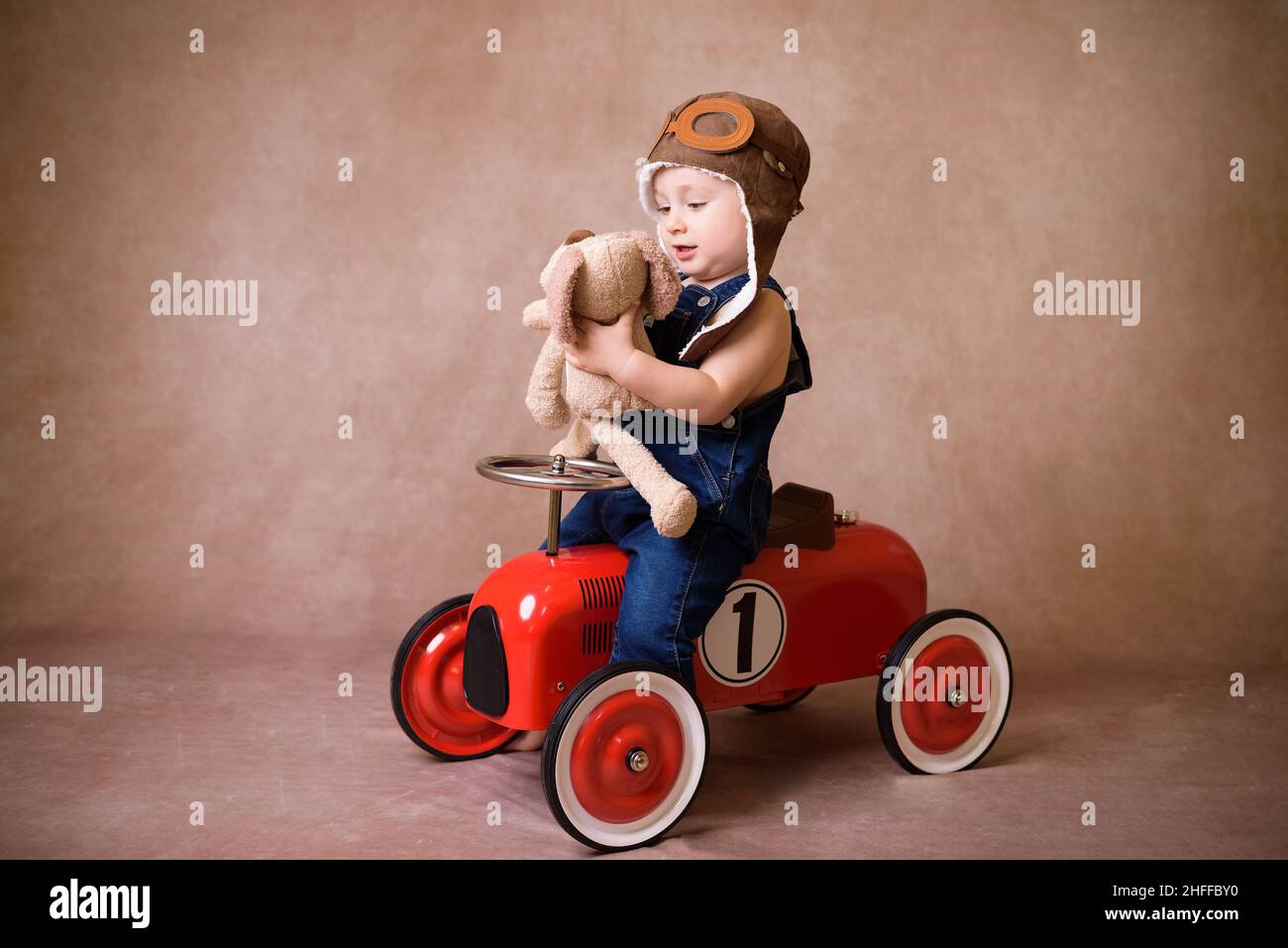 Bambini che cavalcano in auto rossa. Bambino che tiene il sacchetto di Natale. Natale concetto di vacanza Foto Stock
