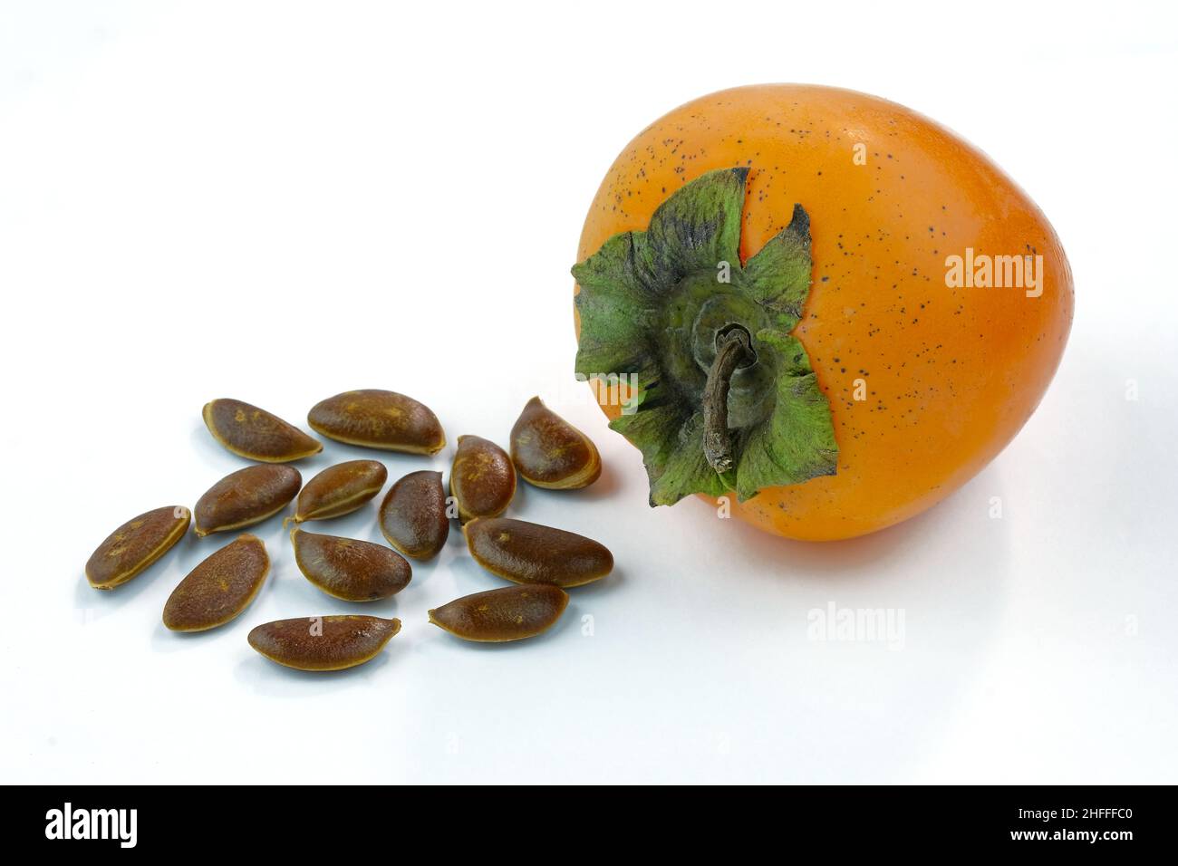Un persimmon maturo intero e semi su sfondo bianco. Semi di persimmon maturi. Arancio di persimmon in autunno. Foto Stock