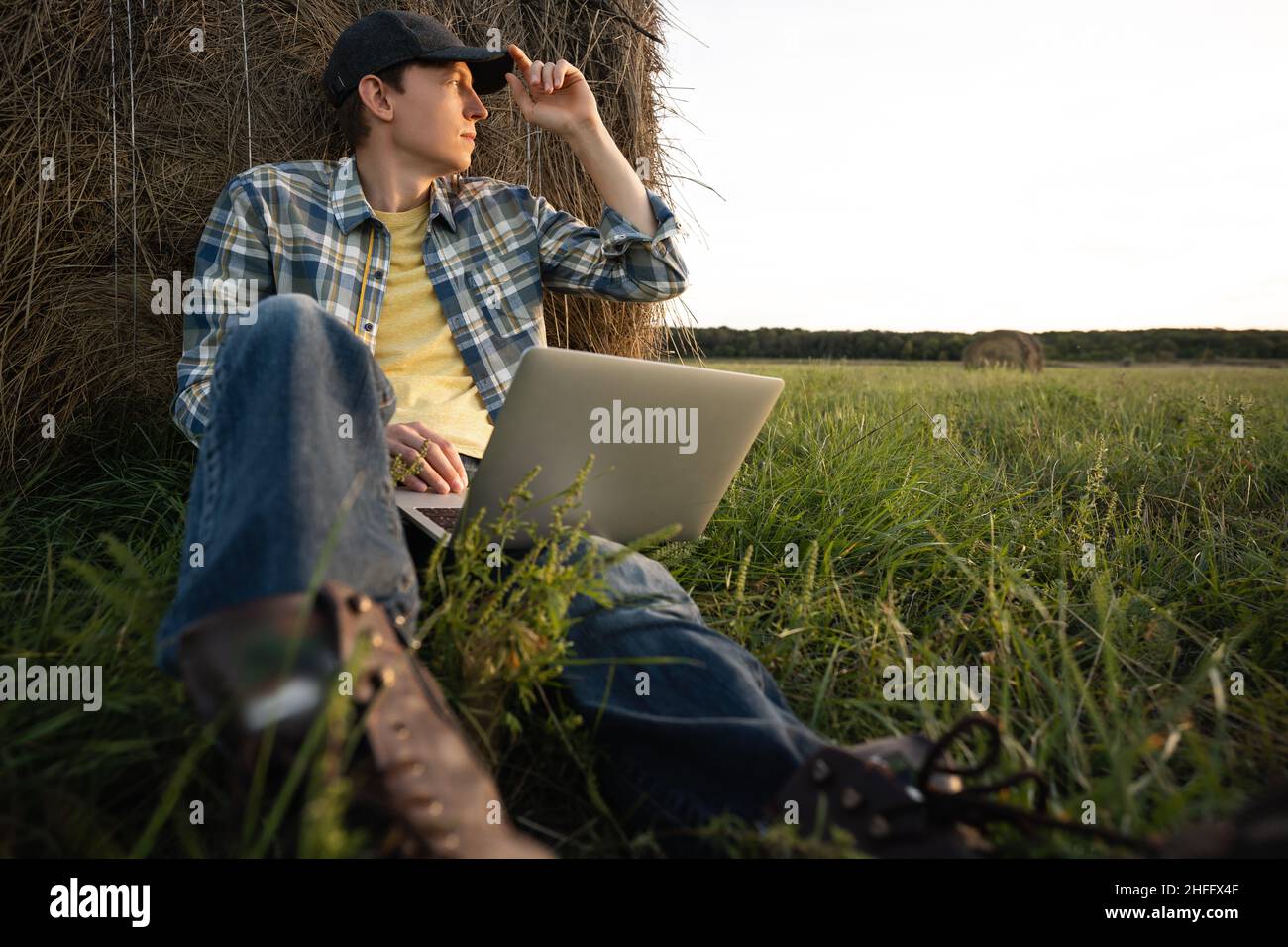 Agricoltore con computer portatile sul campo. Digitalizzazione intelligente dell'agricoltura e dell'agricoltura Foto Stock