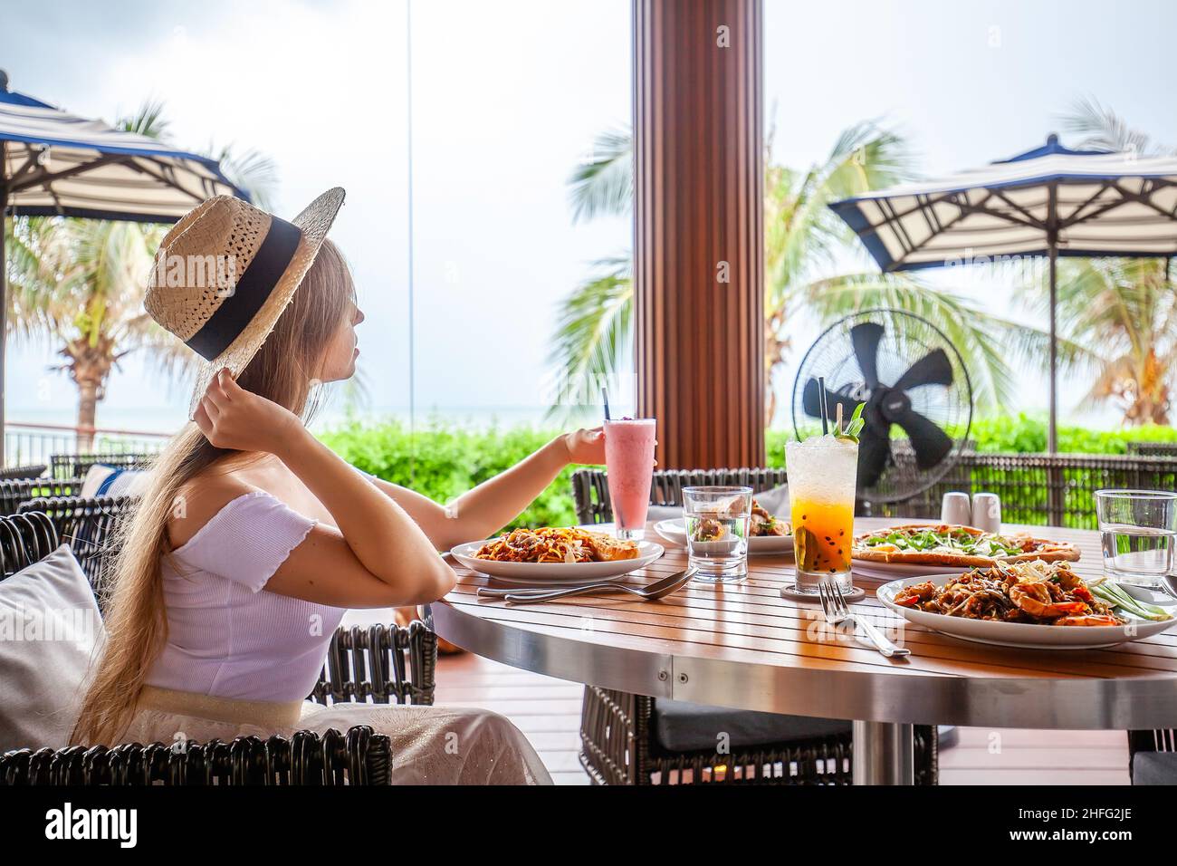 Felice giovane donna che mangia la pasta italiana al ristorante, femmina con cibo al bar Foto Stock