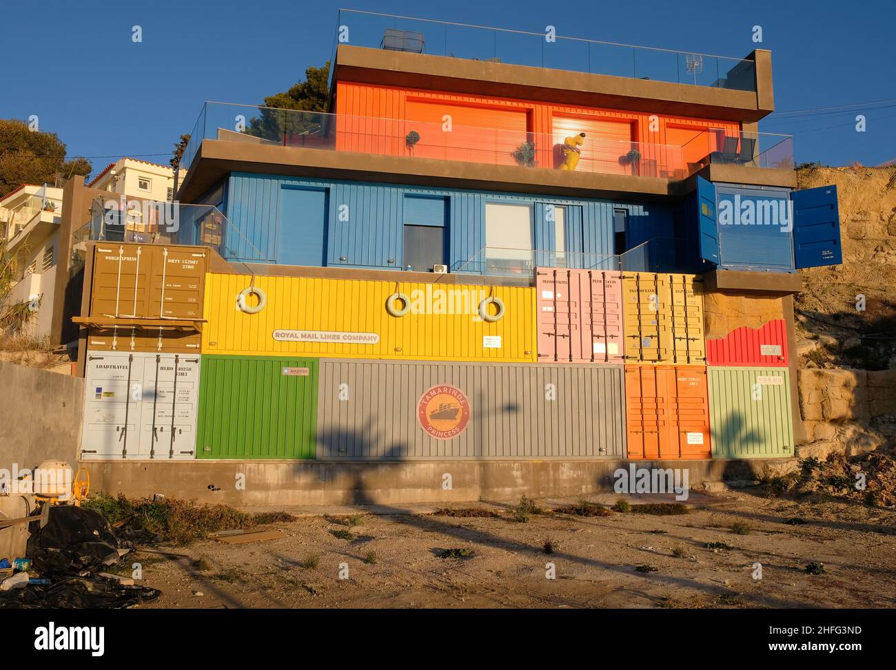 Villajoyosa Alicante Spagna 01.16.22 Casa fatta da contenitori impilati di spedizione. Dipinte in modo luminoso. Logo aziendali. Porte e finestre con chiusura a rullo. Foto Stock