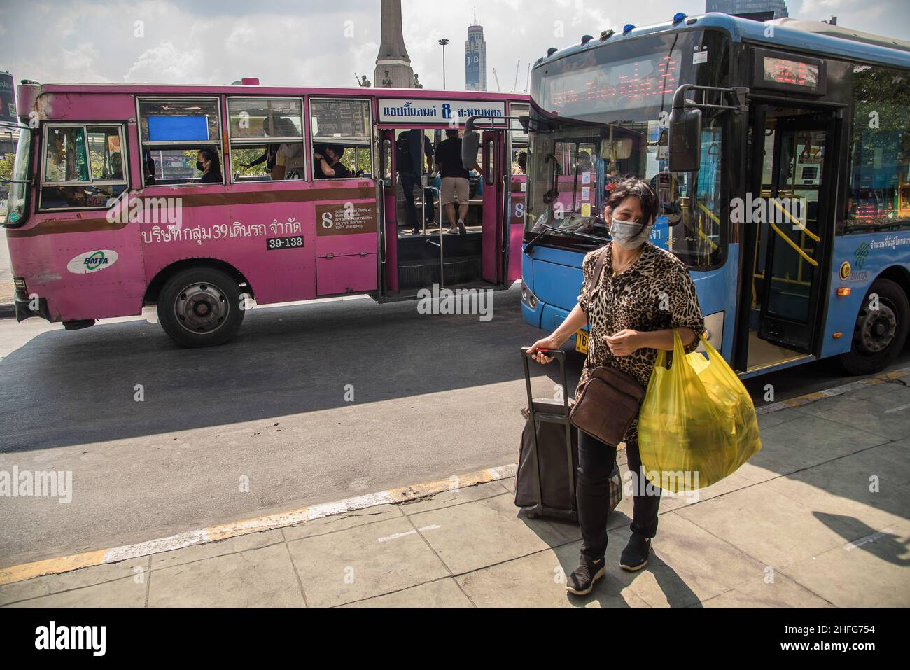 Bangkok, Tailandia. 16th Jan 2022. Una donna che indossa una maschera facciale come misura preventiva contro la diffusione di convivid-19 visto tirare un bagaglio alla fermata dell'autobus del Monumento alla Vittoria a Bangkok. (Foto di Peerapon Boonyakiat/SOPA Images/Sipa USA) Credit: Sipa USA/Alamy Live News Foto Stock