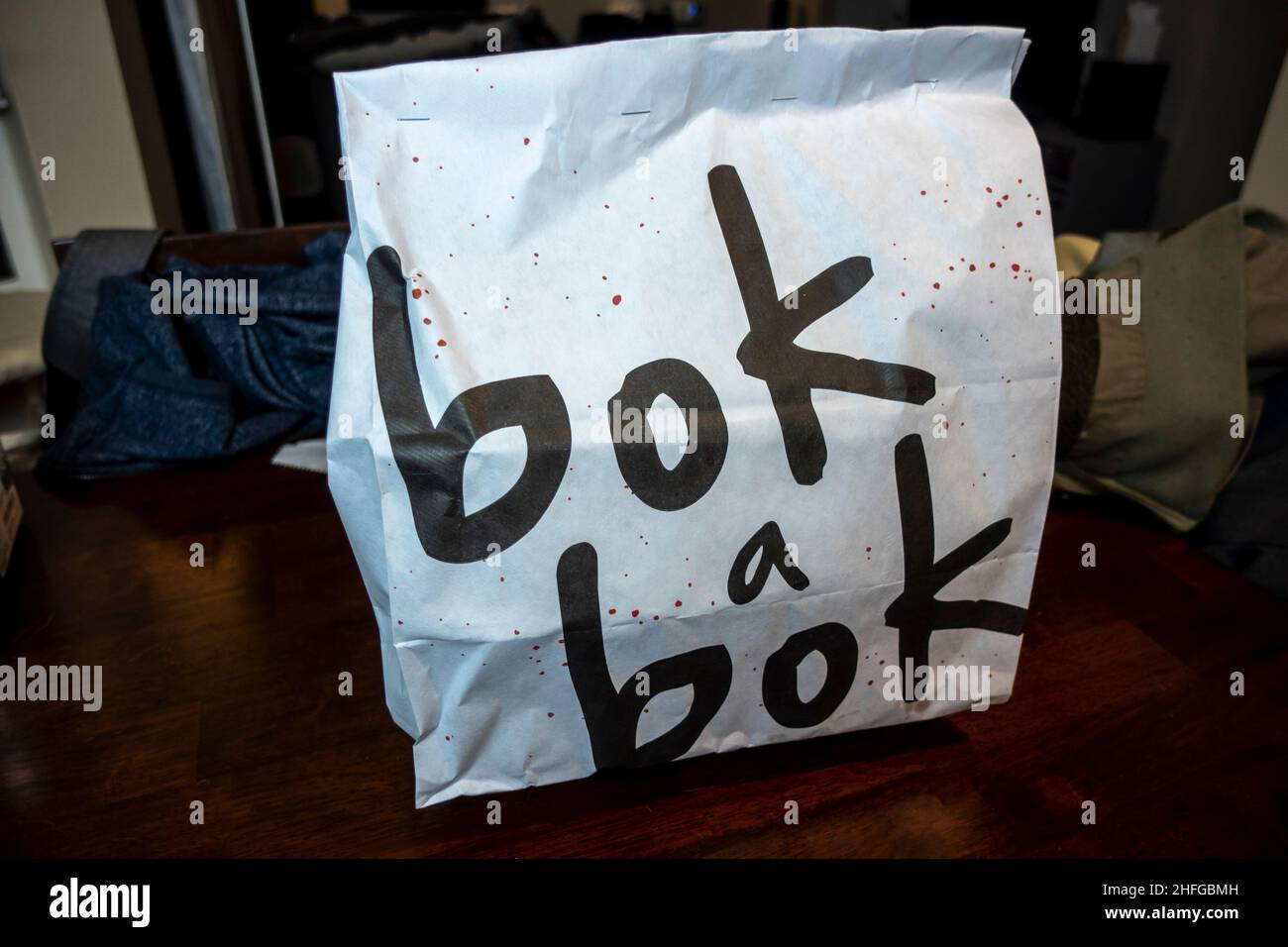 Seattle, WA USA - circa dicembre 2021: Vista di una borsa da asporto da Bok Un ristorante di pollo fritto Bok su un tavolo da pranzo. Foto Stock