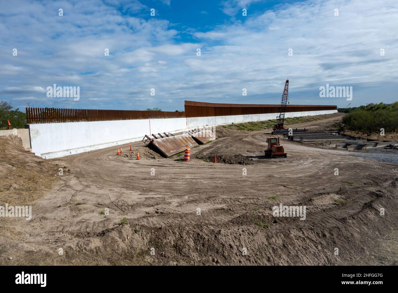 Il muro di confine in acciaio e cemento USA-Messico in costruzione lungo il Rio Grande. McAllen, Texas, Stati Uniti. Foto Stock