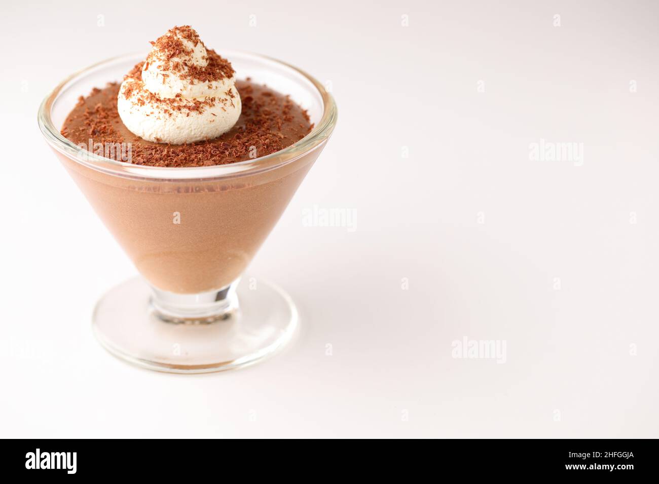 Dessert di mousse al cioccolato in un piatto di vetro conico sormontato da un vortice di crema e cioccolato fondente grattugiato cosparso sulla parte superiore - con spazio copia Foto Stock