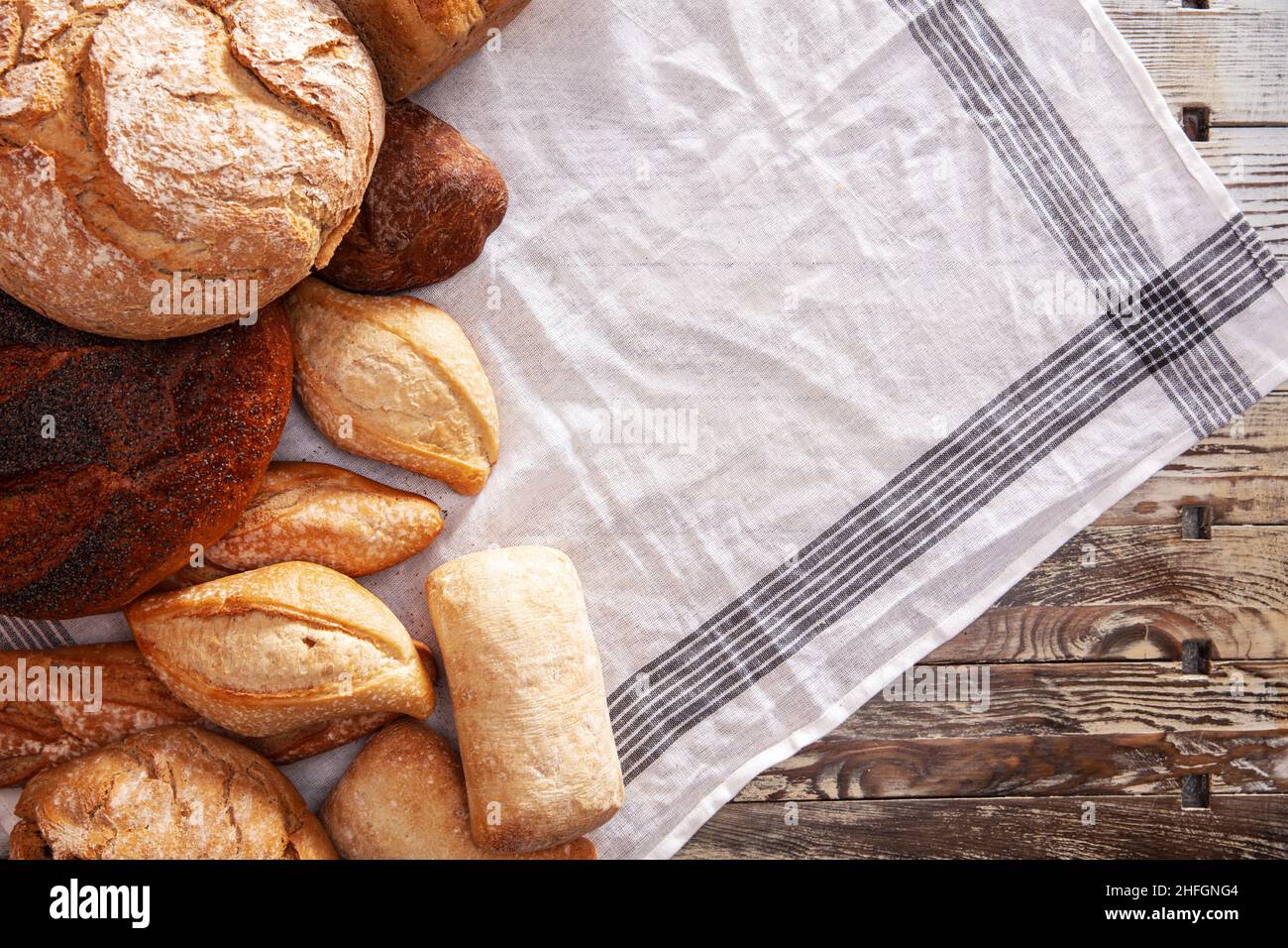 Pane fresco disposto su un tavolo di legno Foto Stock