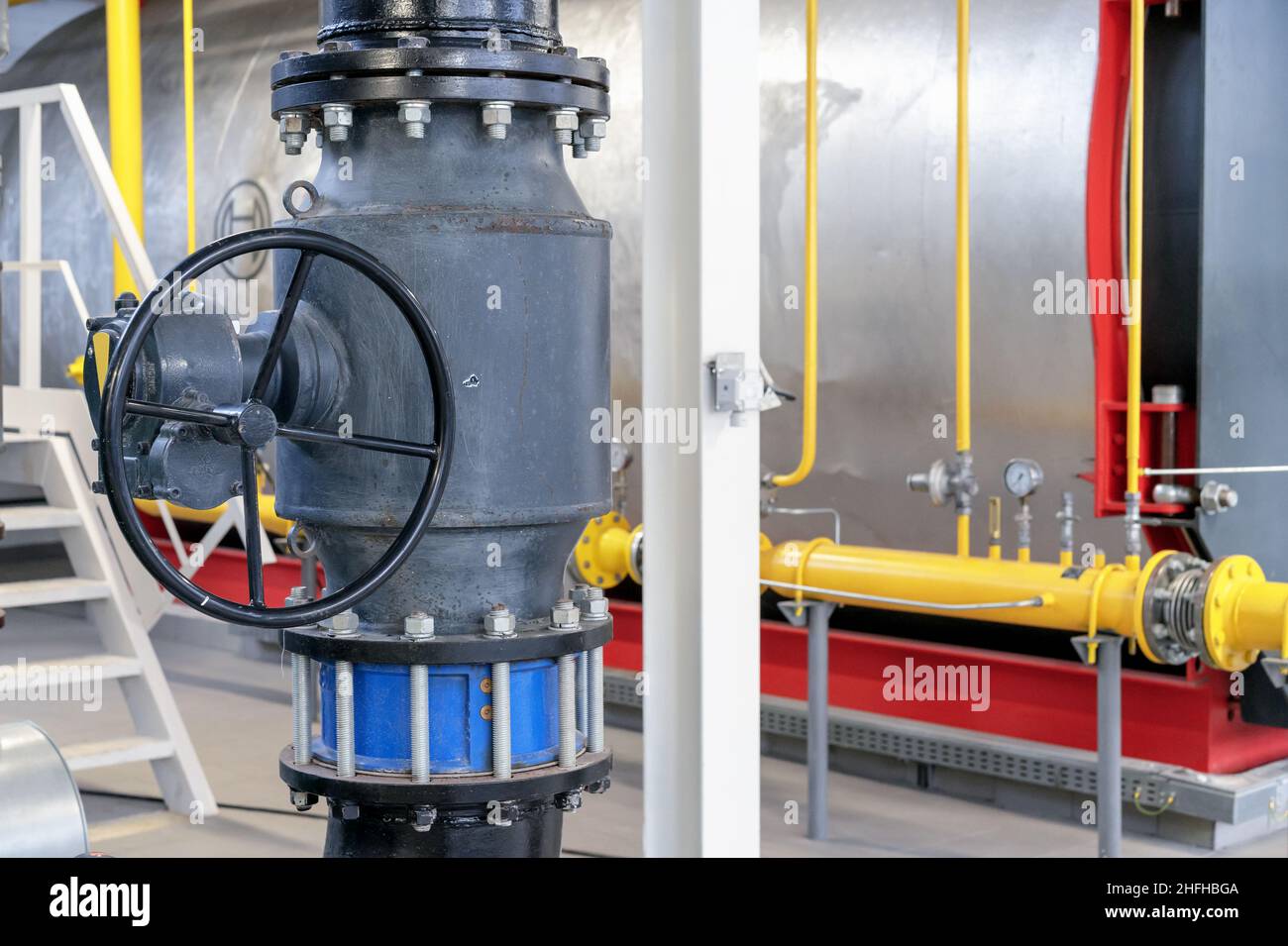 Valvola a saracinesca con riduttore e valvola di ritegno flangiata in un locale caldaia a gas. Foto Stock