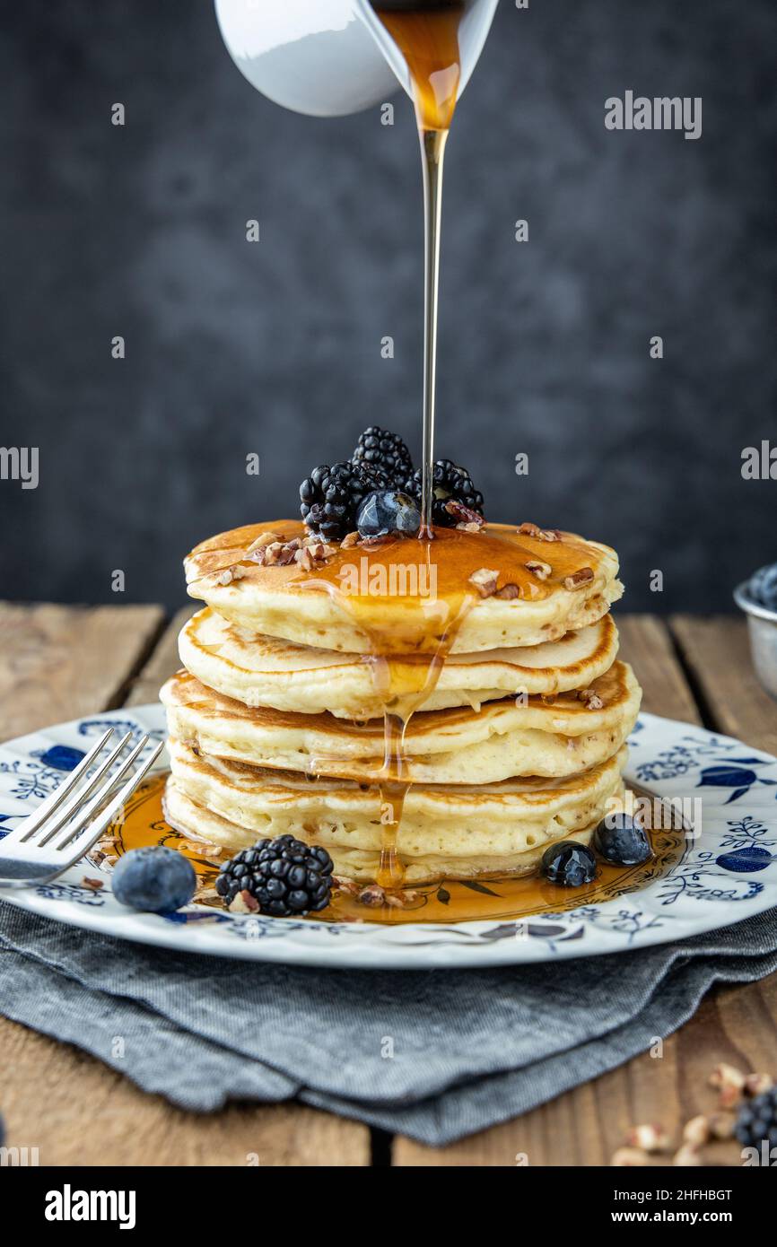 Una pila di pancake caldi con sciroppo versato sulla parte superiore Foto Stock