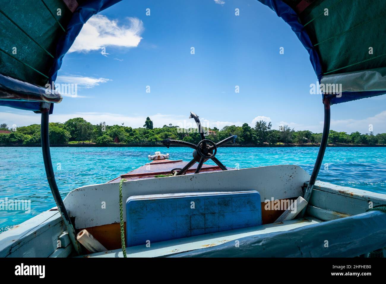 Stagione estiva Zanzibar. All'interno di una barca tradizionale sotto il cielo blu in una strada vicino all'isola della prigione, Stone Town, Unguja, Tanzania. Foto Stock