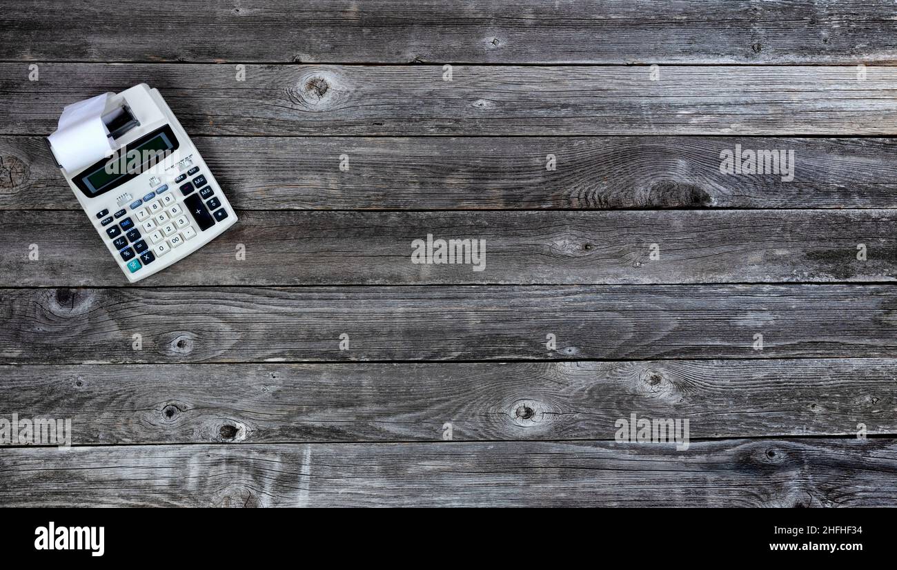 Tavolo da ufficio in legno invecchiato con calcolatore d'affari retrò e nastro di carta. Vista dall'alto con ampio spazio per le copie. Foto Stock