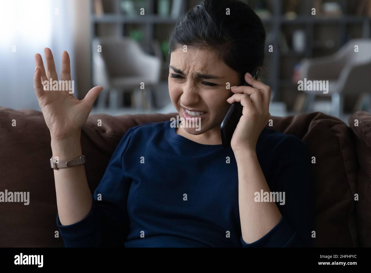 Infelice giovane indiana che tiene spiacevoli telefonate conversazione. Foto Stock