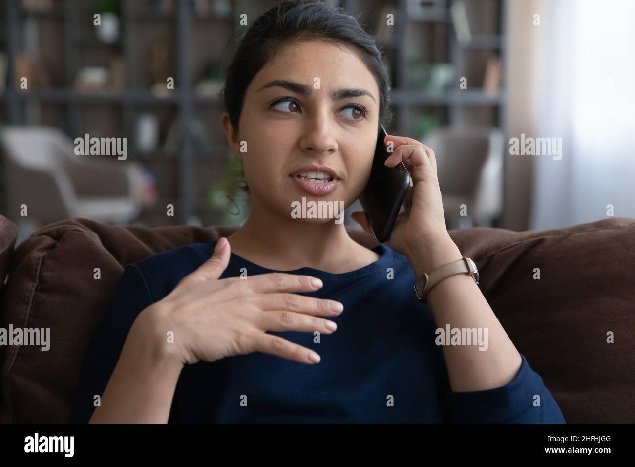 Felice giovane donna indiana che tiene piacevole conversazione con il cellulare. Foto Stock