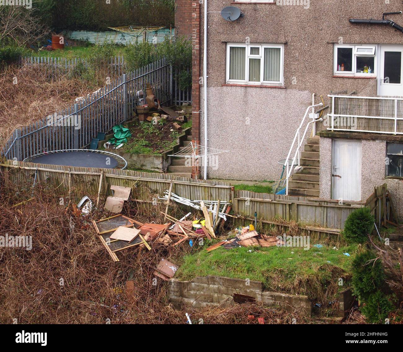 Gennaio 2013 - rifiuti gettati sopra la recinzione da vicino del consiglio appartamenti e appartamenti di proprietà a Swansea, Galles del Sud Foto Stock