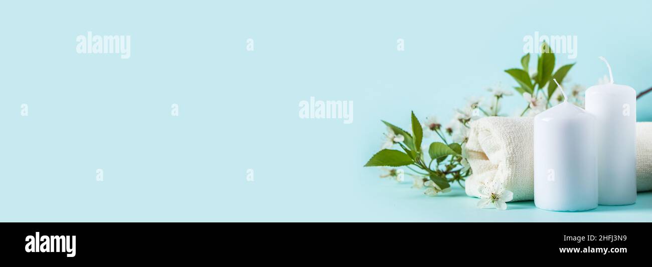 Prodotti naturali biologici di bellezza per spa e aromaterapia. Olio essenziale aromatico, candele e un asciugamano su sfondo blu. Concetto di relax, luogo Foto Stock