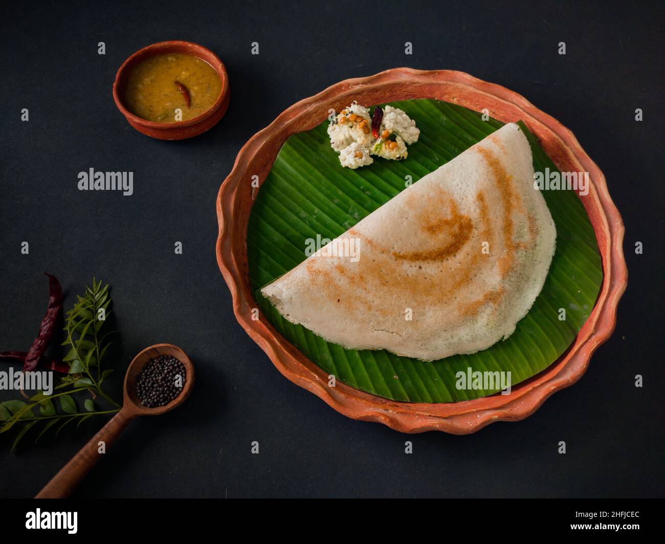 tradizionale cibo sud indiano masala dosa, sambar e chutney di cocco servito su piatto di argilla e foglia di banana. studio shot. copia sfondo spazio. Foto Stock