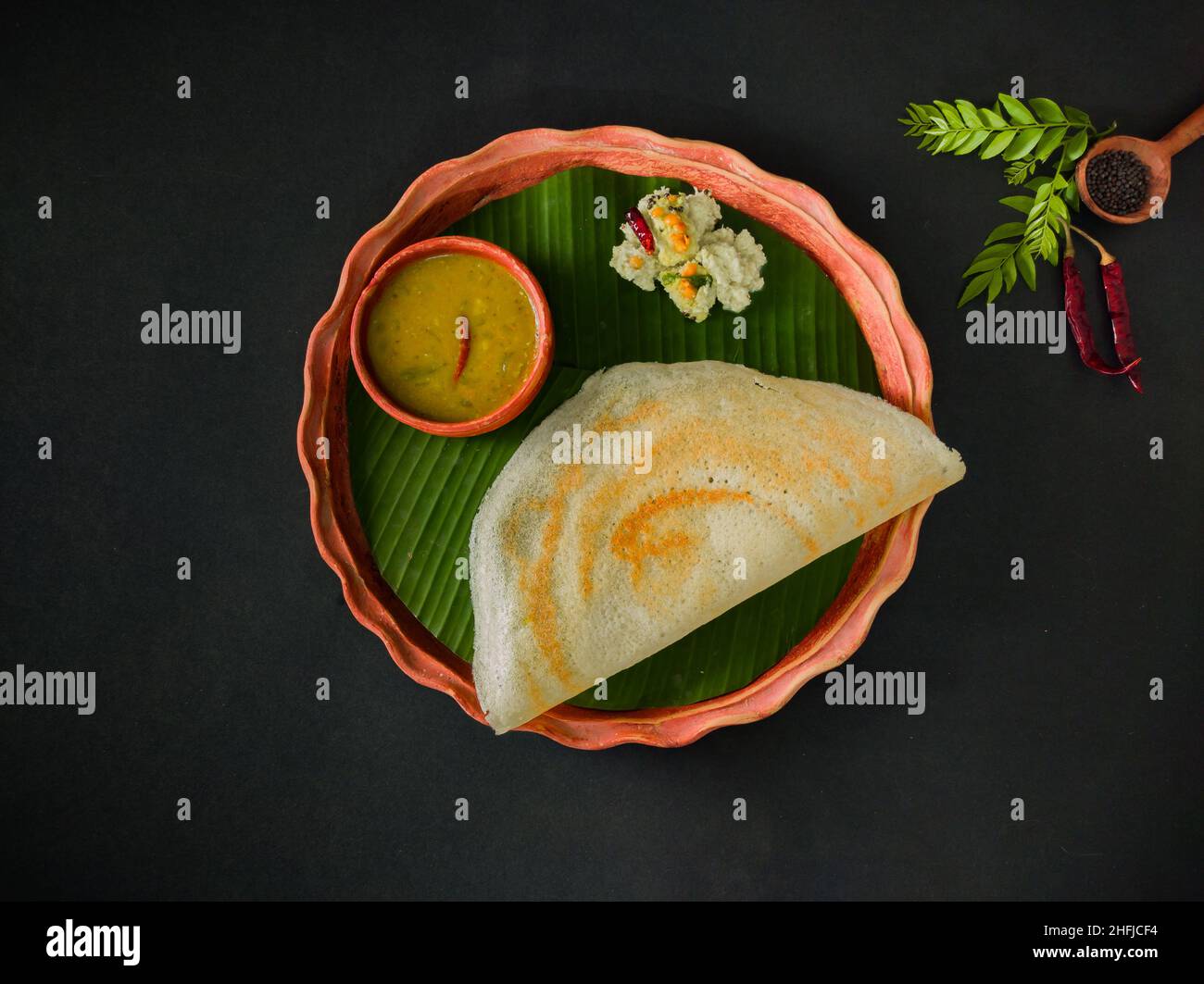 tradizionale cibo sud indiano masala dosa, sambar e chutney di cocco servito su piatto di argilla e foglia di banana. studio shot. copia sfondo spazio. Foto Stock