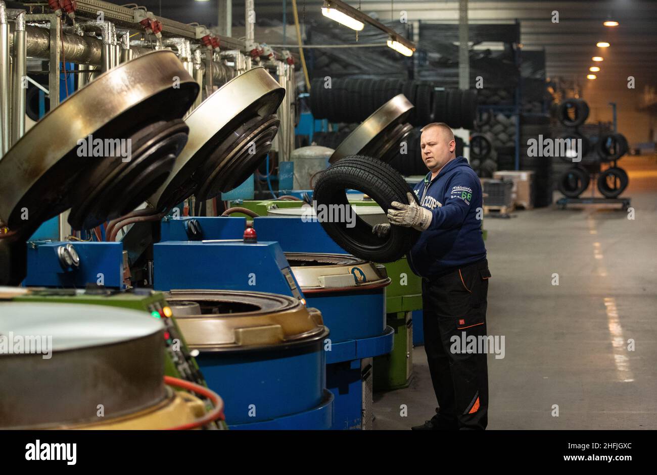 Dissen, Germania. 15th Dic 2021. Thomas Pietka valuta il processo di vulcanizzazione su un pneumatico ricostruito. In Germania, ogni anno vengono prodotti 570.000 pneumatici da rottame. Finora, gli pneumatici ricostruiti non hanno goduto di una buona reputazione. Una rete di produttori di pneumatici vuole cambiare questa impostazione, sostenuta dalla Fondazione Federale tedesca per l'ambiente. (A dpa 'rete vuole ottenere pneumatici ricostruiti dalla trappola immagine') credito: Friso Gentsch/dpa/Alamy Live News Foto Stock