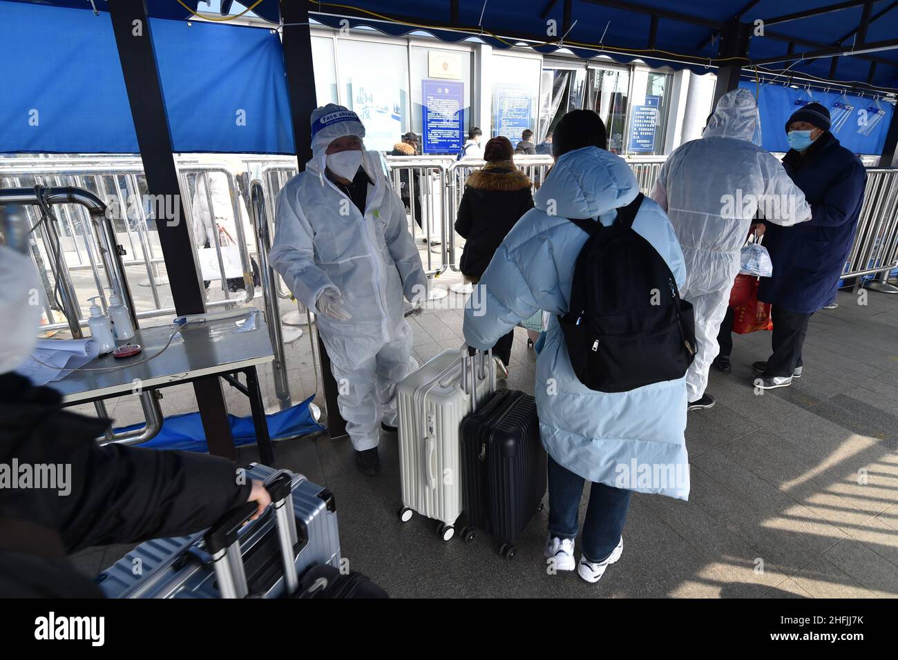 NANJING, CINA - 17 GENNAIO 2022 - gli operatori di prevenzione epidemica controllano le temperature dei passeggeri, i codici sanitari e le carte di viaggio all'ingresso di Nanji Foto Stock