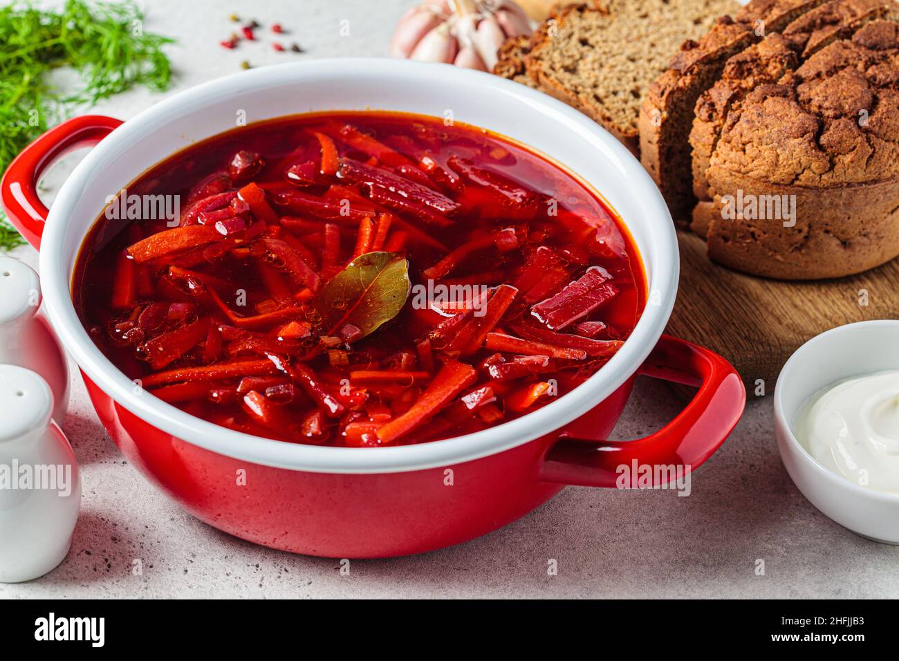 Padella di minestra di barbabietole borsch con aglio, panna acida e aneto. Cucina russa o Ucraina. Foto Stock