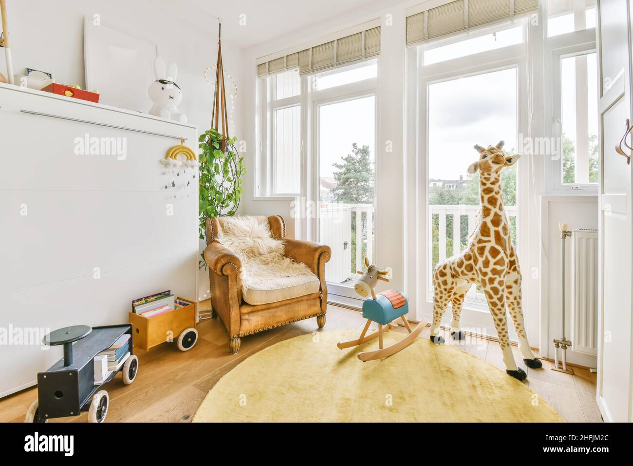 Lussuosa camera per bambini con giocattoli e tappeto giallo al giorno Foto Stock