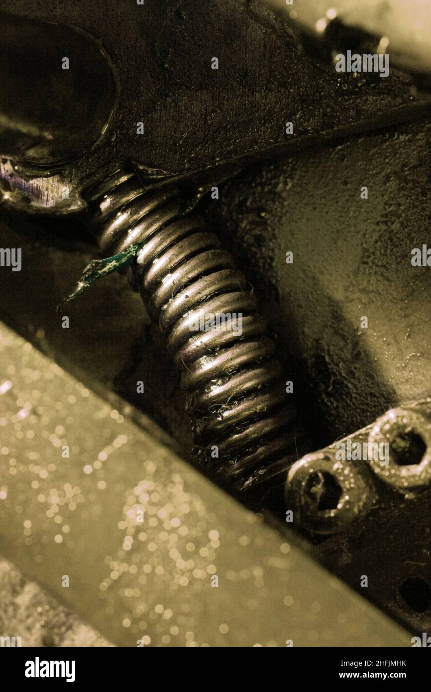 Primo piano molla lubrificata compressa, parte di un macchinario tecnico. Foto Stock