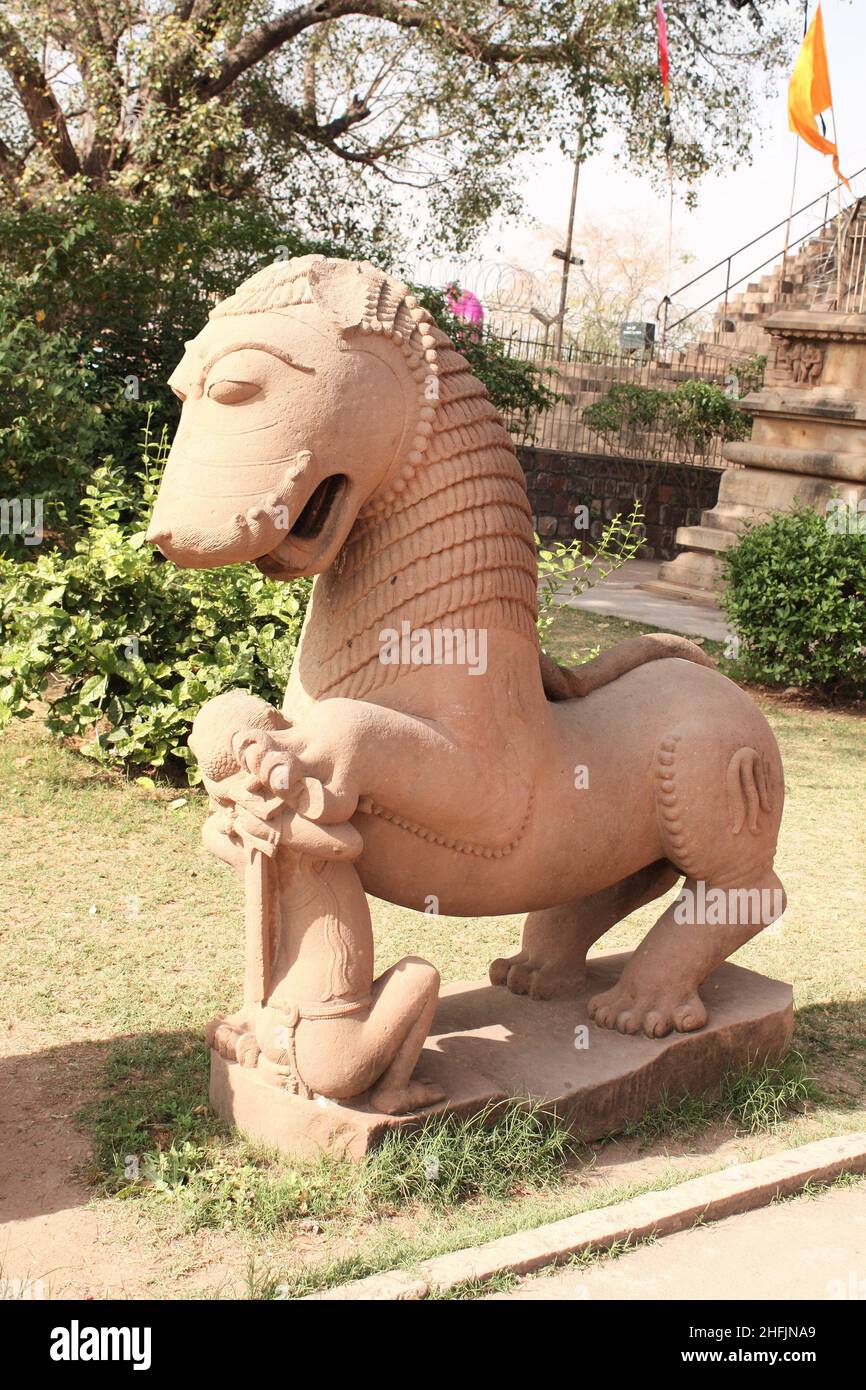 Antica statua di pietra di un re combattente e un leone vicino al tempio di Khajuraho, Madya Pradesh, India. Sito patrimonio dell'umanità dell'UNESCO Foto Stock