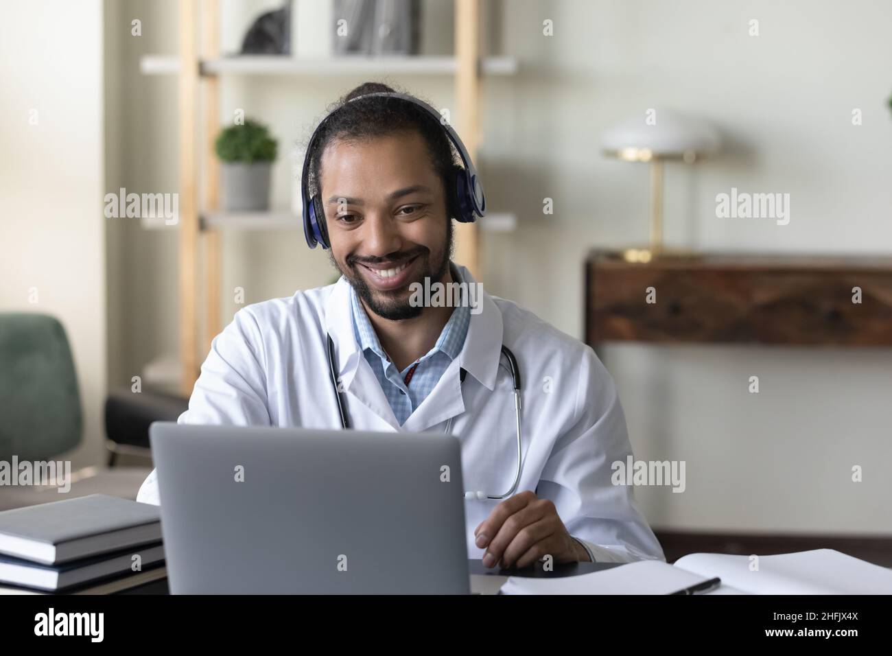 Buon medico africano GP giovane americano che tiene la videochiamata. Foto Stock