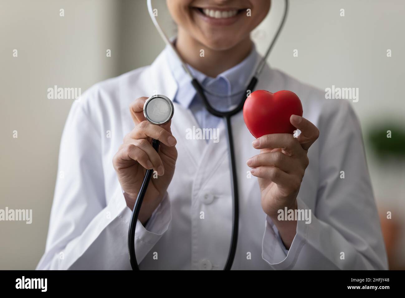 Closeup sorridente medico indiano femminile che raccomanda il controllo regolare delle malattie cardiache. Foto Stock