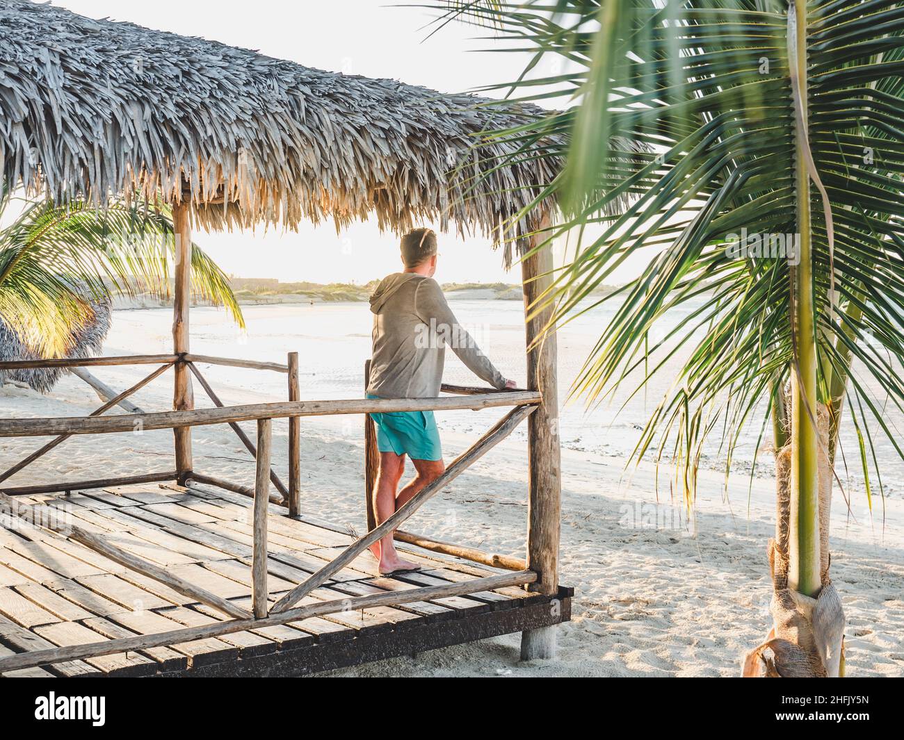 Bell'uomo sulla spiaggia che guarda in lontananza Foto Stock
