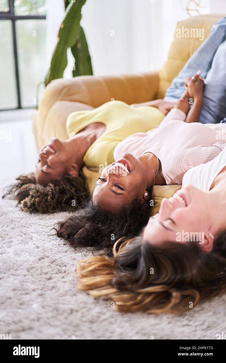 Foto verticale di un'amicizia Donna felice sorridente a divano. I giovani che si divertono insieme a casa. Foto Stock