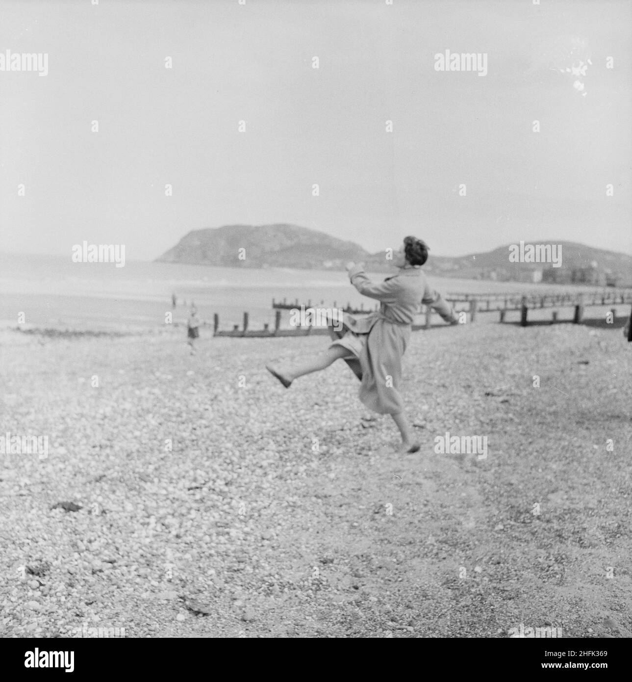 Llandudno, Conwy, Galles, 15/05/1954. Hilda Laing sulla spiaggia di Llandudno durante un viaggio del personale di Laing. Nel 1947, dopo una pausa di sette anni, Laing aveva risuscitato le loro "uscite di zona" per il personale e le loro famiglie, con viaggi in maggio e giugno. Nel 1954 sono state previste sette uscite per cinque settimane a maggio e giugno. Questo viaggio è stato per il personale e le loro famiglie provenienti dal Galles del Nord e dall'Inghilterra nordoccidentale. Foto Stock