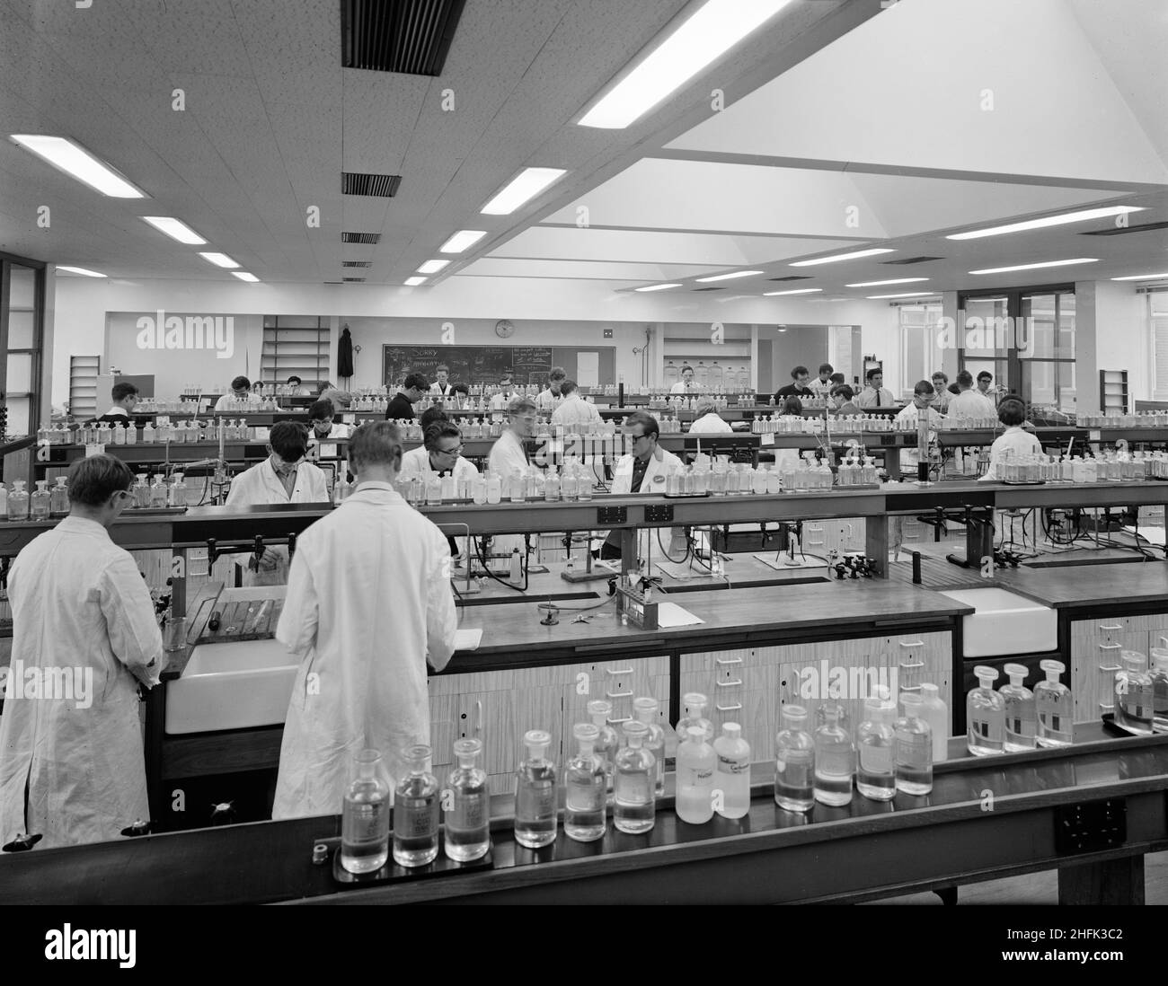 Parson's Field House, Durham University, Durham, County Durham, 29/10/1964. Un laboratorio di chimica impegnato presso la Durham University con studenti impegnati in lavori sperimentali. Tra il 1963 e il 1964, la Northern Region of Laing's Construction Company costruì un complesso di edifici per la Durham University, composto da chimica, geologia e un edificio matematico, mostrato sulle mappe come 'Science Laboratories'. Questa fotografia è stata pubblicata nel dicembre 1964 nella newsletter mensile di Laing "Team Spirit". Mostra uno dei laboratori di chimica nel complesso, descritto nella newsletter come avente quattro diversi gas Foto Stock