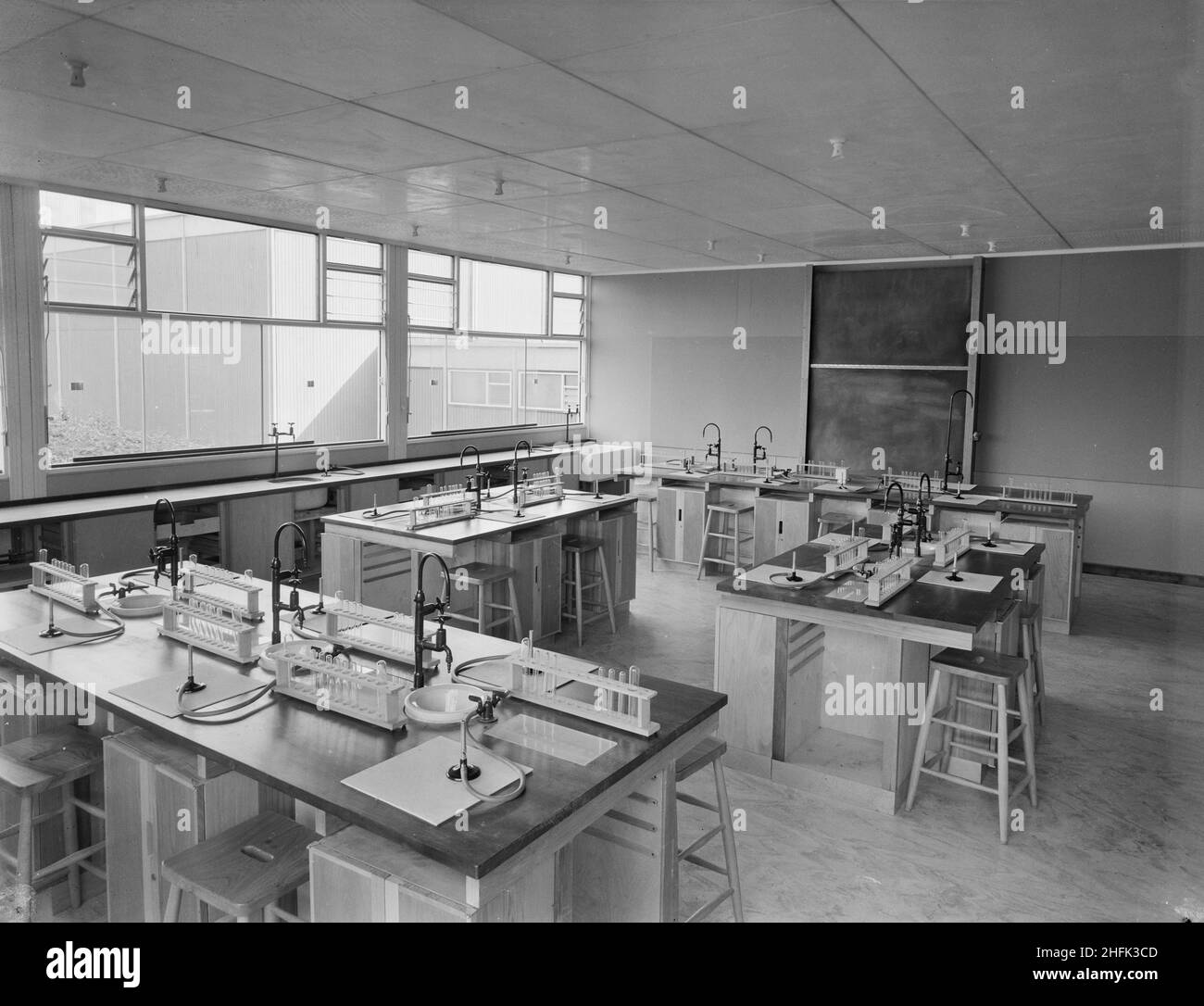 County High School, Gedling Road, Arnold, Gedling, Nottinghamshire, 11/09/1959. L'interno di uno dei laboratori scientifici della Arnold County High School, che mostra banchi dell'isola dotati di lavandini, rubinetti a gas con bruciatori Bunsen e rack di provette. Il blocco scientifico ospitava laboratori di chimica, biologia, fisica, matematica e scienze generali al piano terra e al primo piano, e al secondo piano c'era un teatro con posti a sedere rialzati, un laboratorio ottico e aree geografiche e disegni tecnici. Questa foto è stata presentata nel numero di ottobre 1959 di Team Spirit, The Laing compa Foto Stock