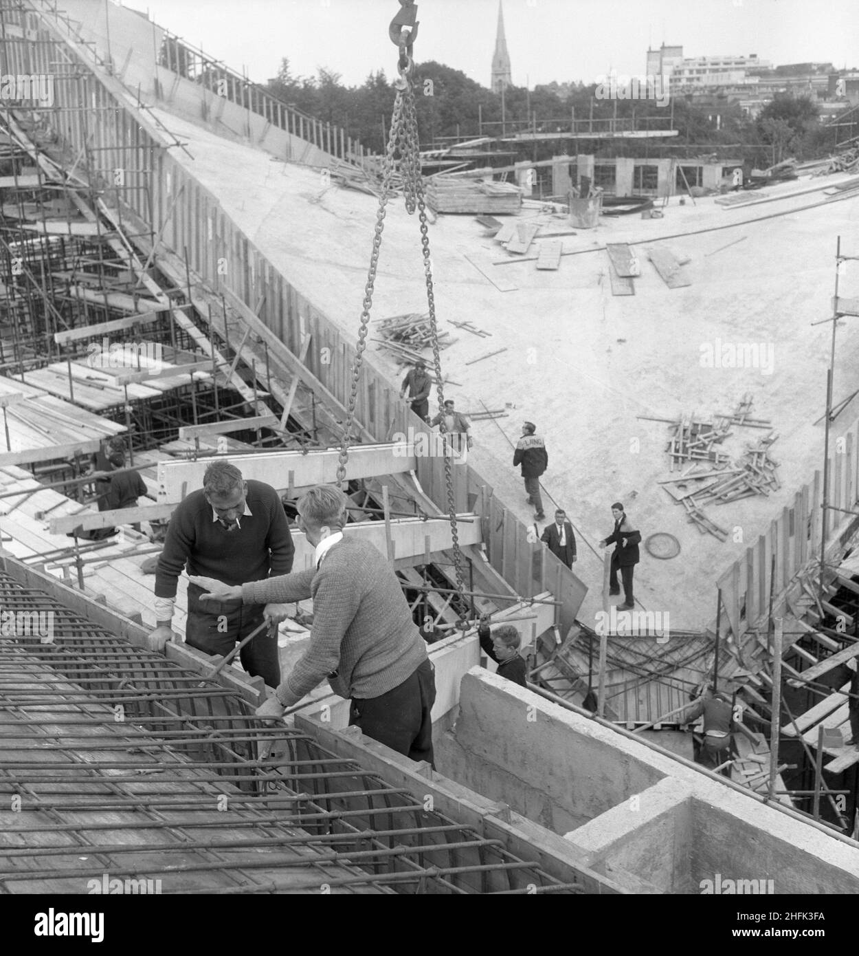 Commonwealth Institute, Kensington High Street, Kensington, Londra, 07/09/1961. Lavoratori che installano nervature in calcestruzzo prefabbricato per la sezione esterna del tetto nell'angolo occidentale della sala espositiva del Commonwealth Institute. Laing costruì l'Istituto del Commonwealth tra l'ottobre 1960 e l'ottobre 1962 per sostituire l'ex Istituto Imperiale che doveva essere demolito per fare posto a nuove strutture presso l'Imperial College. L'edificio consisteva in un blocco amministrativo a quattro piani che ospitava una biblioteca, un ristorante, una sala riunioni e una sala conferenze e un blocco a due piani separato contenente un cinema con un A. Foto Stock