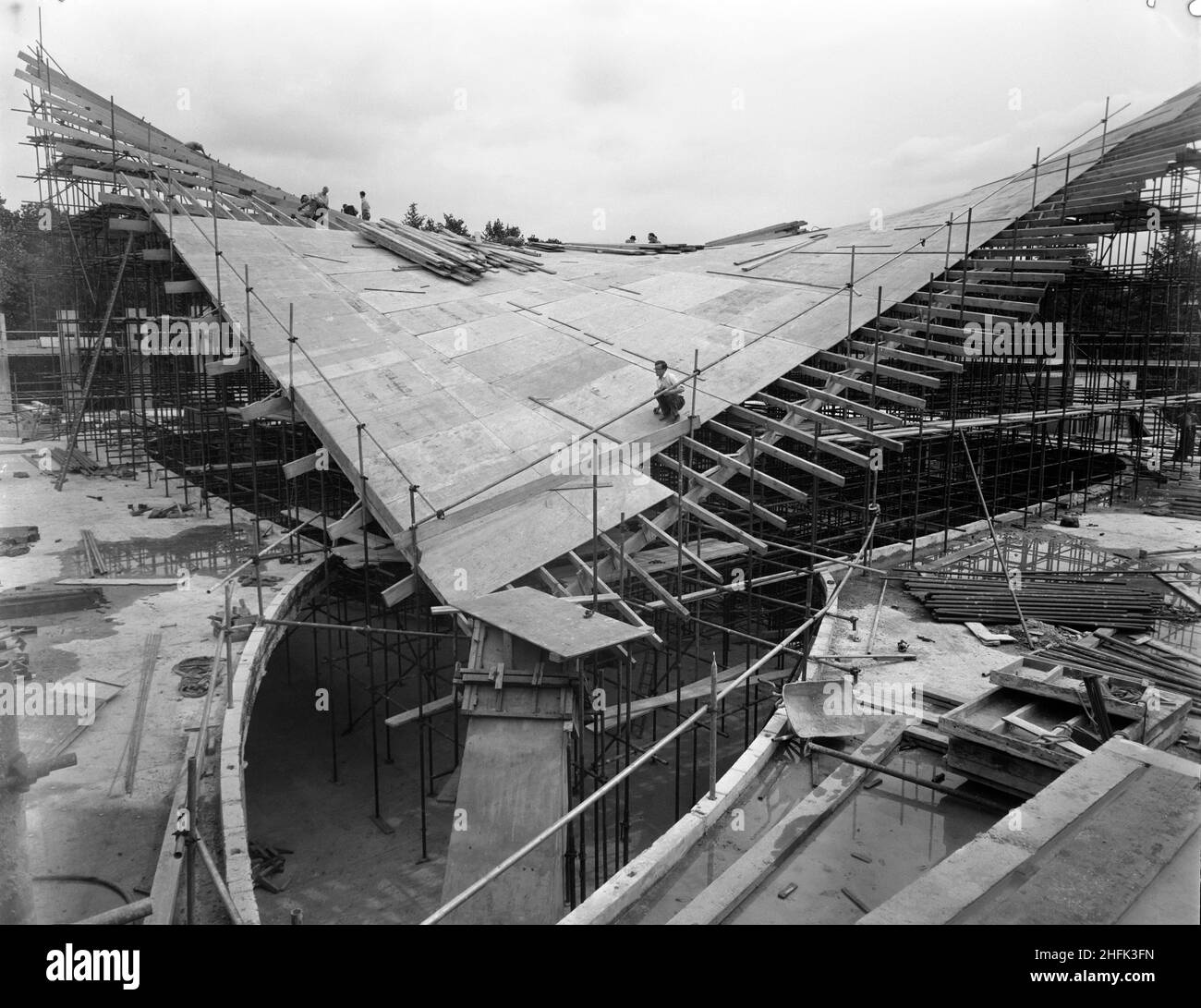Commonwealth Institute, Kensington High Street, Kensington, Londra, 27/07/1961. Operai che costruiscono la cassaforma in legno per la sezione centrale del tetto a paraboloide iperbolico della sala espositiva del Commonwealth Institute. Laing costruì l'Istituto del Commonwealth tra l'ottobre 1960 e l'ottobre 1962 per sostituire l'ex Istituto Imperiale che doveva essere demolito per fare posto a nuove strutture presso l'Imperial College. L'edificio consisteva in un blocco amministrativo a quattro piani che ospitava una biblioteca, un ristorante, una sala riunioni e una sala conferenze e un blocco separato a due piani contenente un cinema w Foto Stock