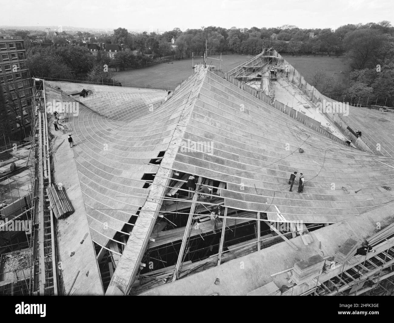 Commonwealth Institute, Kensington High Street, Kensington, Londra, 23/10/1961. Una vista sopraelevata che guarda a nord e che mostra i progressi della costruzione del tetto della sala espositiva del Commonwealth Institute. Laing costruì l'Istituto del Commonwealth tra l'ottobre 1960 e l'ottobre 1962 per sostituire l'ex Istituto Imperiale che doveva essere demolito per fare posto a nuove strutture presso l'Imperial College. L'edificio consisteva in un blocco amministrativo a quattro piani che ospita una biblioteca, un ristorante, una sala riunioni e una sala conferenze e un blocco separato a due piani che contiene un cinema con una galleria d'arte abo Foto Stock