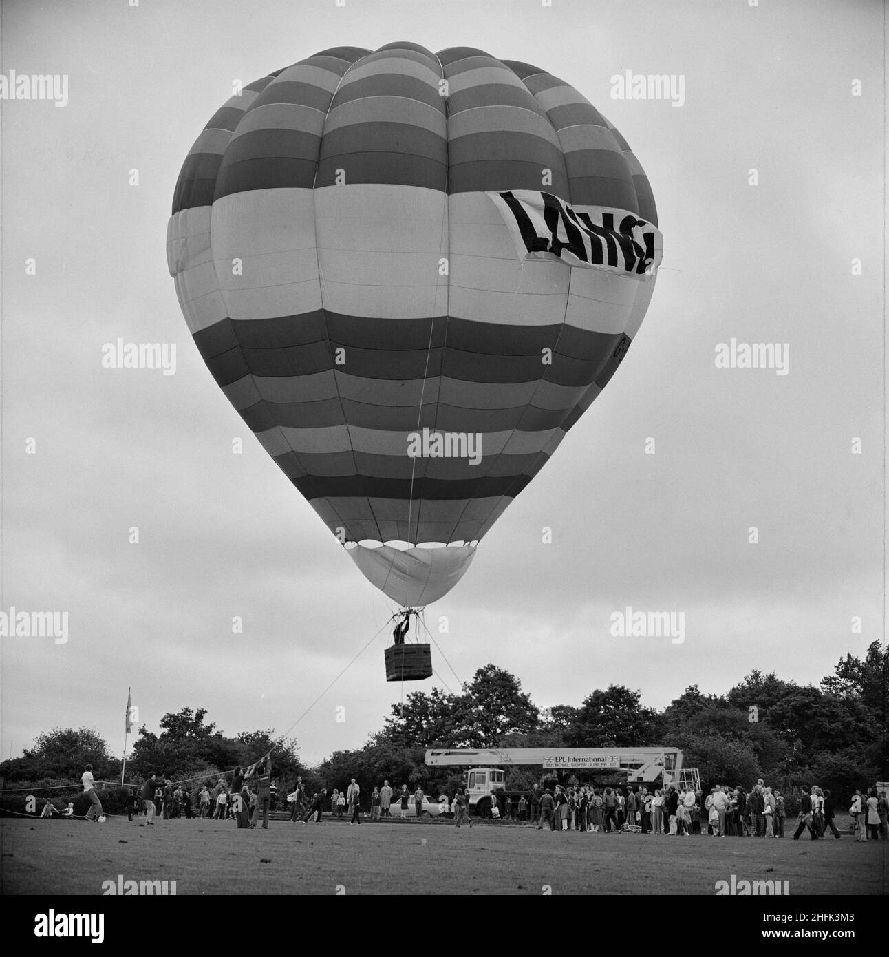 Laing Sports Ground, Rowley Lane, Elstree, Barnet, Londra, 18/06/1977. Una mongolfiera ad aria calda abbellita da una bandiera di Laing che decollo dal campo sportivo di Elstree durante i festeggiamenti annuali del Laing Gala Day. Questa fotografia è stata utilizzata nel numero di luglio 1977 di Team Spirit, la newsletter della Laing Company. Foto Stock