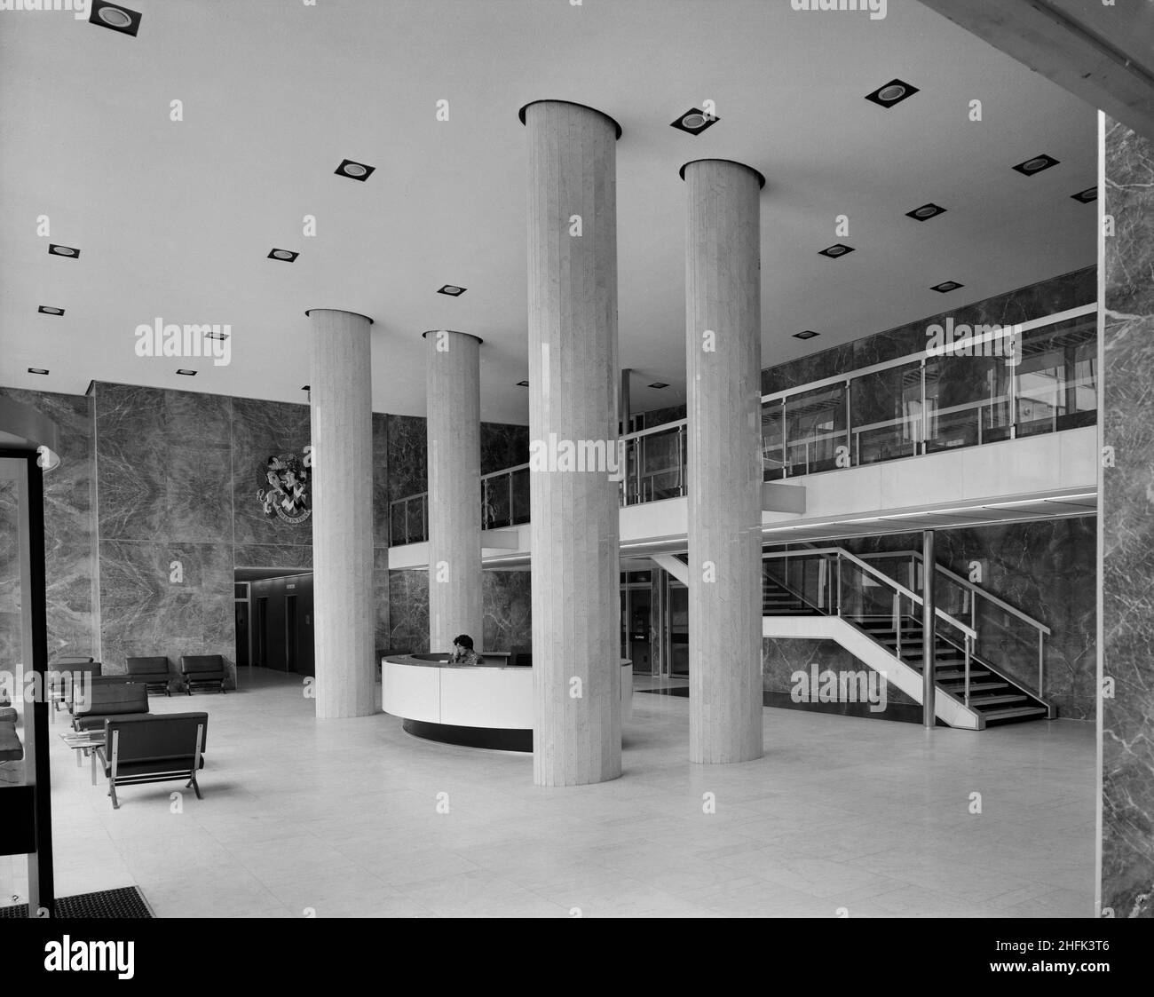 Paternoster Square, City of London, 23/06/1965. L'area di ricevimento di un edificio di uffici presso lo sviluppo di Paternoster, che mostra una scrivania tra quattro grandi colonne. I lavori sullo sviluppo di Paternoster sono stati condotti in una joint venture da John Laing Construction Limited, Trollope and Colls Limited e George Wimpey and Company Limited. Lo schema prevedeva la riqualificazione di un sito di sette acri sul lato nord della Cattedrale di St Paul&#x2019. Il sito era stato quasi interamente devastato durante un raid incendiario nel dicembre 1940. Lo sviluppo consisteva in una serie di blocchi per uffici, un punto vendita Foto Stock