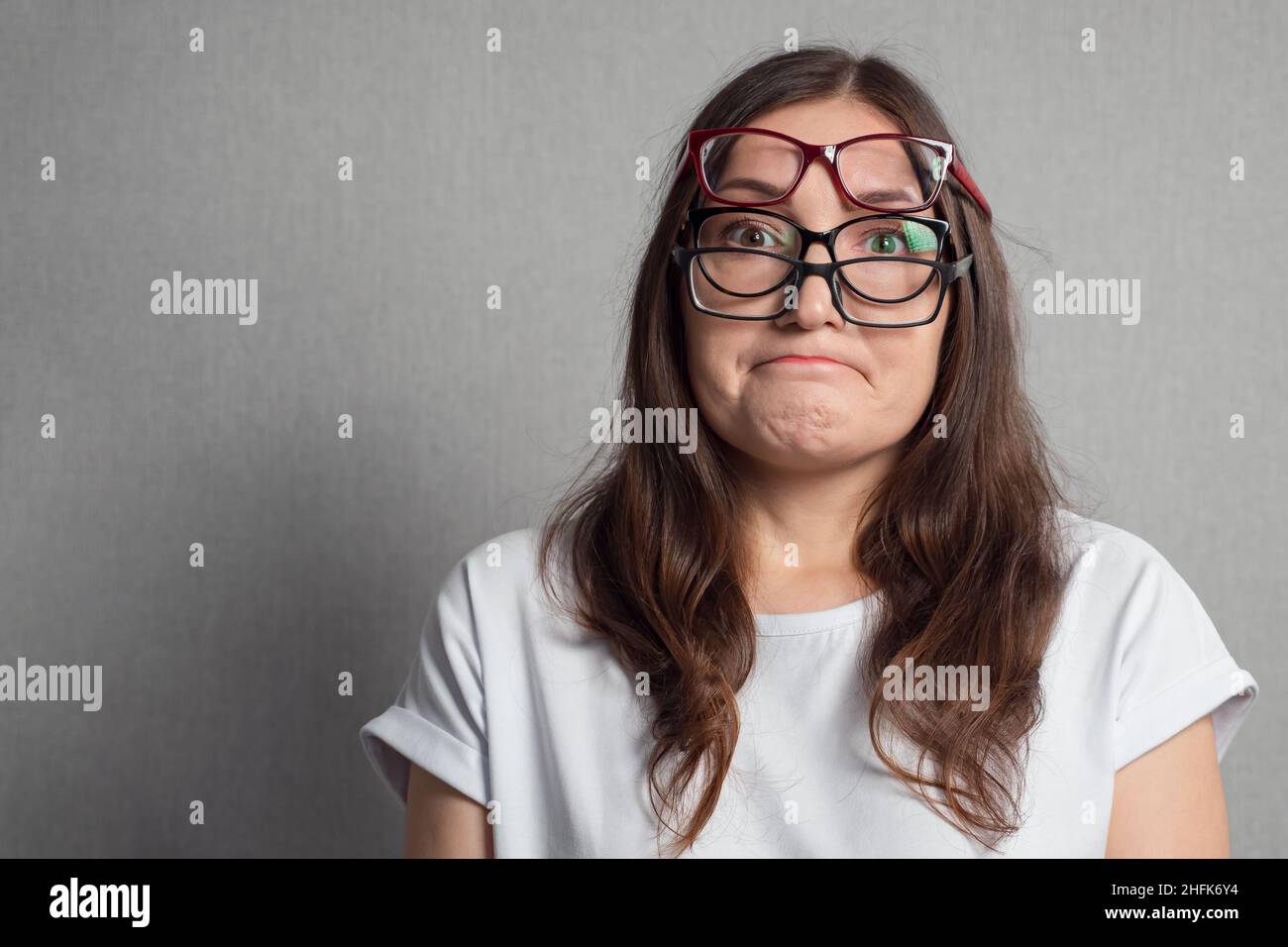 La donna mette su parecchi vetri per migliorare la vista difettosa Foto Stock