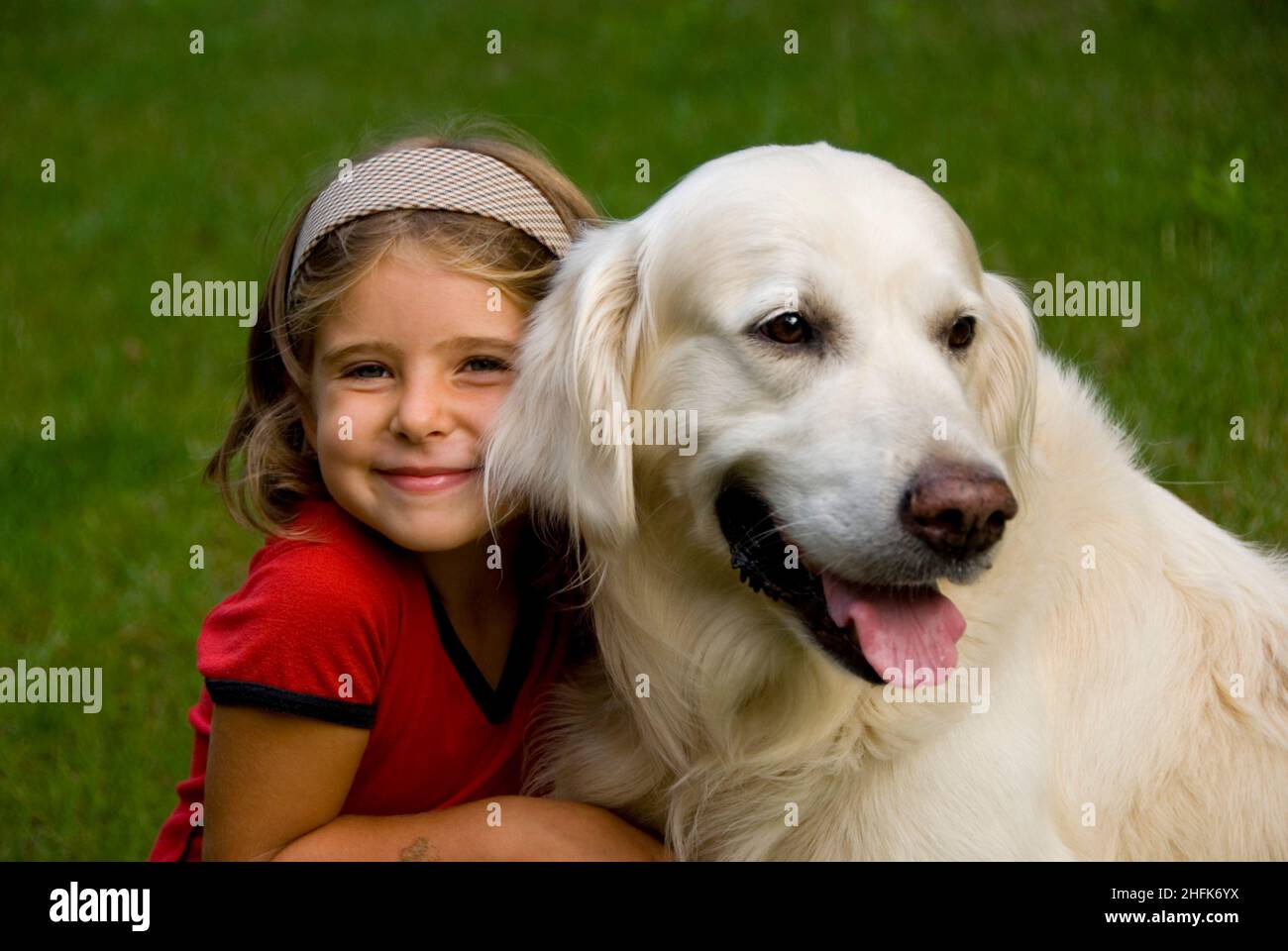 Piccola bambina di otto anni con il suo cane Golden Retriever Foto Stock