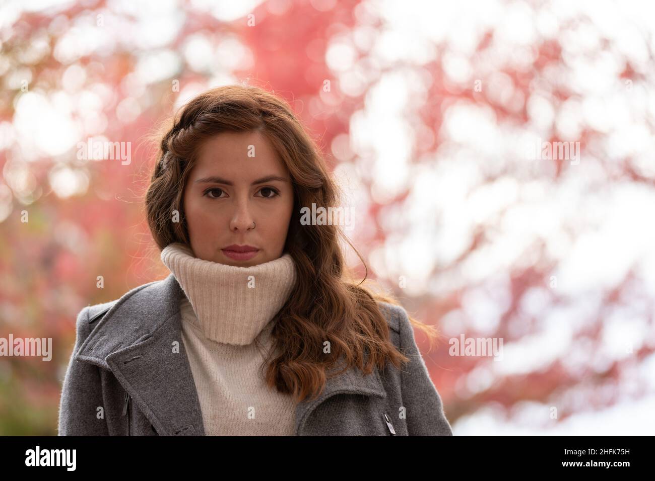 Primo piano ritratto di una giovane donna che guarda fotocamera molto serio Foto Stock