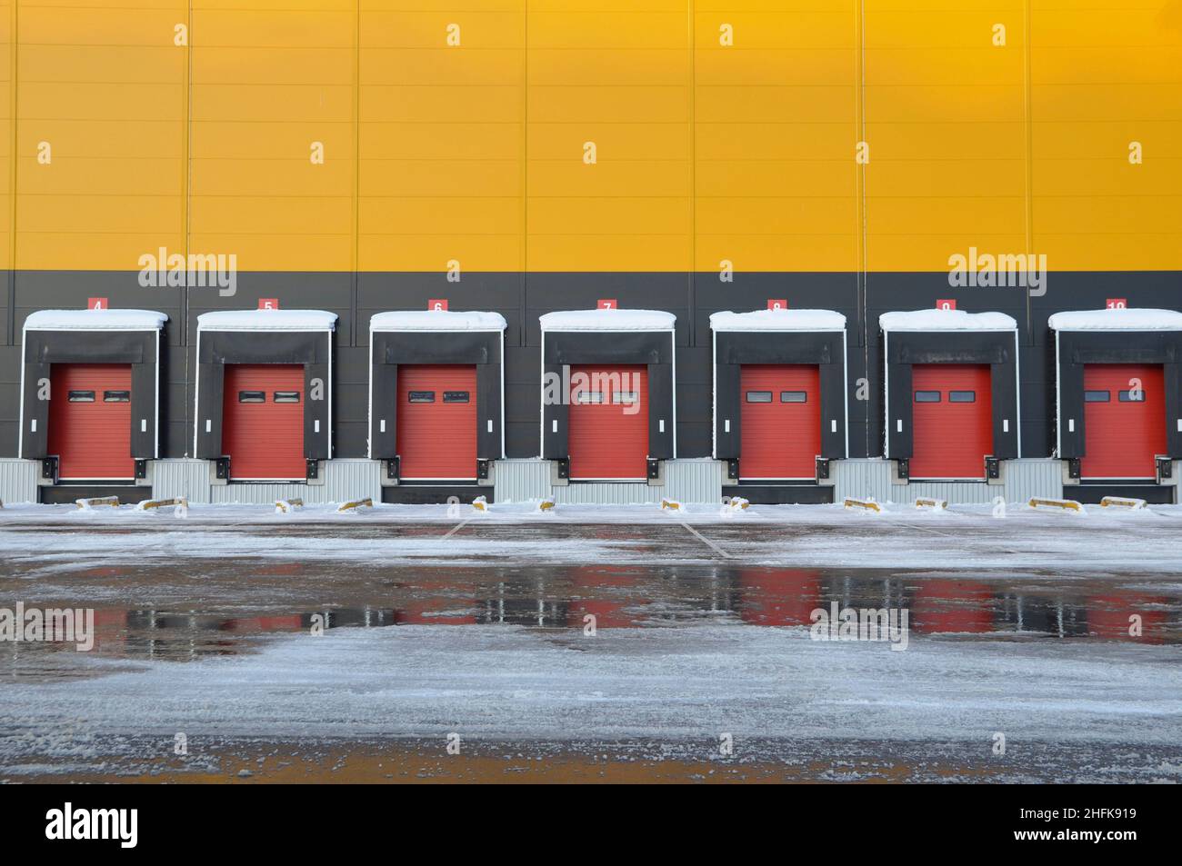 Vista esterna di un grande magazzino in inverno. Banchine di carico. Foto Stock