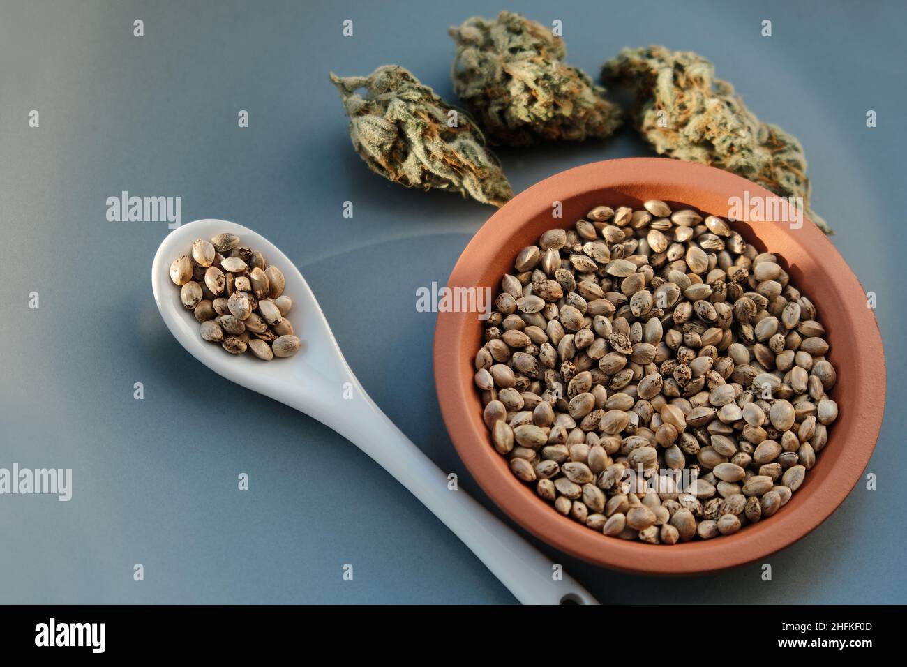 Un mazzo di semi di cannabis su un piatto con foglia verde. Grano di canapa  su sfondo grigio, posa piatta. Granella di marijuana, vista dall'alto Foto  stock - Alamy