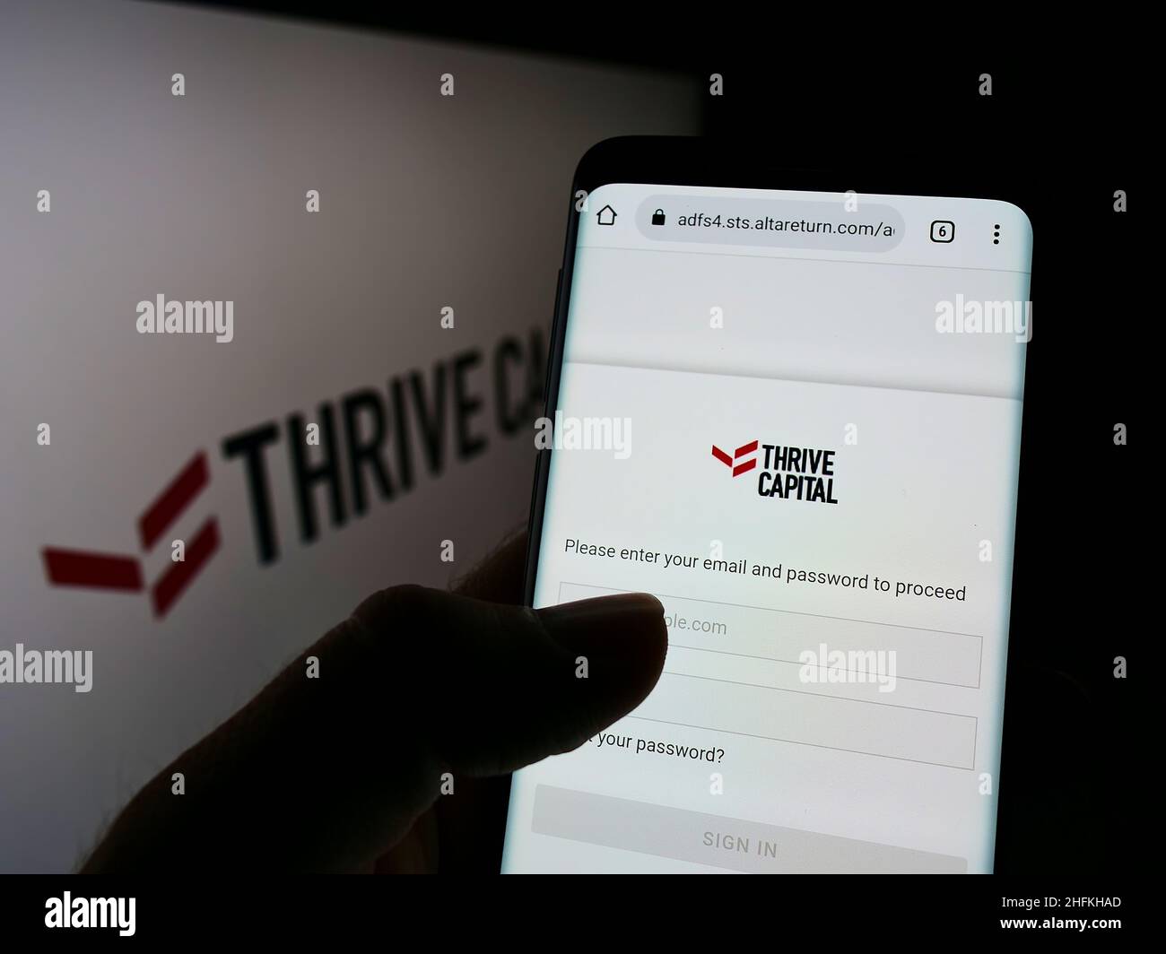 Persona che detiene il cellulare con il sito web della società statunitense THRIVE Capital Management LLC sullo schermo di fronte al logo. Concentrarsi sul centro del display del telefono. Foto Stock