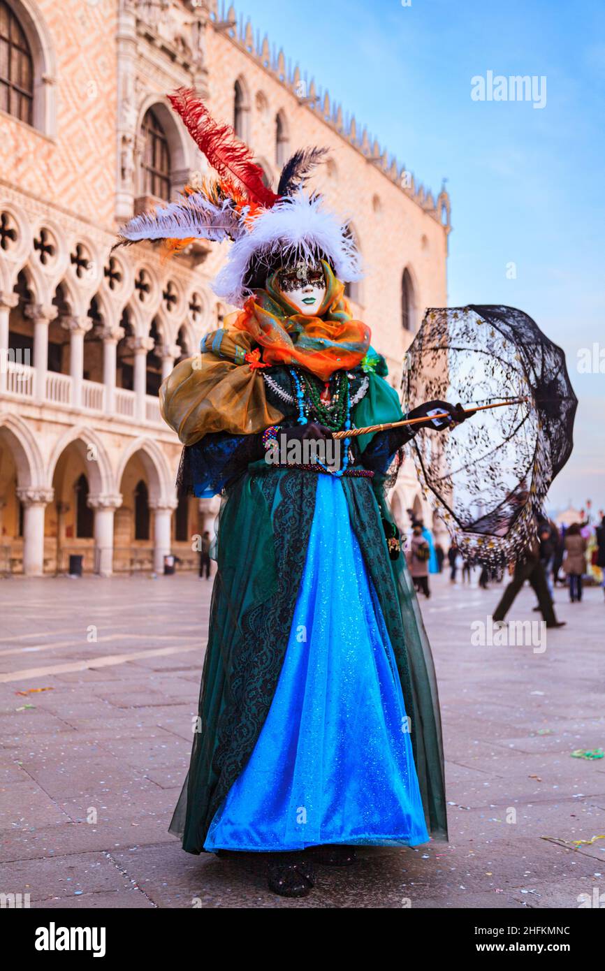 Donna in coloratissimo costume veneziano, cappello e maschera, posa al Carnevale di Venezia, Carnevale di Venezia, Italia Foto Stock