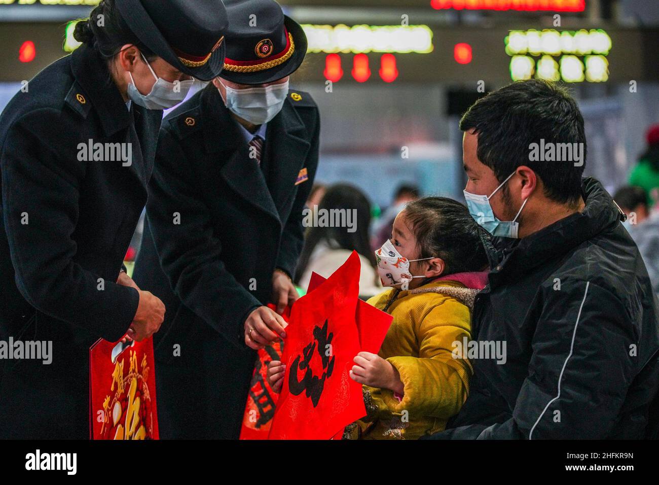 (220117) -- GUIYANG, 17 gennaio 2022 (Xinhua) -- i membri del personale danno regali di Capodanno ai passeggeri alla stazione ferroviaria di Guiyang a Guiyang, provincia sudoccidentale di Guizhou, 17 gennaio 2022. Si prevede che la stagione di viaggio del Festival di primavera 2022 della Cina vedrà 1,18 miliardi di viaggi passeggeri, in aumento del 35,6% anno su anno, ma 20,3% inferiore a quello del 2020, ha detto il Ministero dei Trasporti. La stagione di viaggio di 40 giorni, nota anche come Chunyun, è iniziata lunedì e molte persone si reuniranno con le loro famiglie per il Capodanno lunare, o il Festival di primavera, che cade il 1 febbraio di quest'anno. (Xin Foto Stock