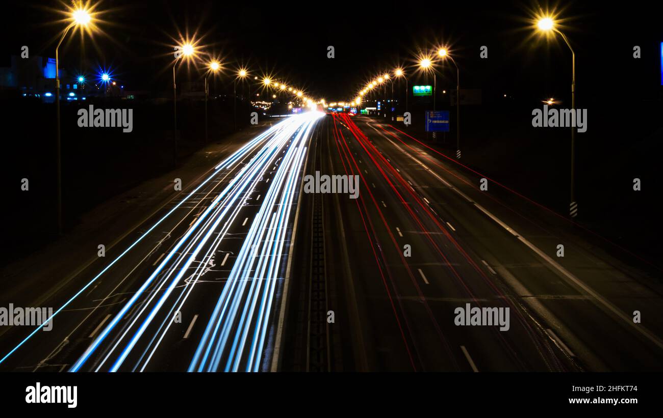 traffico notturno, semafori su una strada grande, vista dall'alto, luci bianche e rosse, linee. Foto Stock